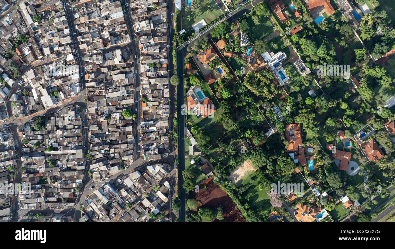 Ribeirão PRETO, SP - 21.04.2024: DESIGUALDADE SOCIAL RP - immagine tratta da un drone, mostra la comunità Jardim progresso accanto al condominio di lusso Quinta da Boa Vista, a sud di Ribeirão Preto, nell'interno di São Paulo. Rapporto pubblicato il 15 gennaio, al World Economic Forum che riunisce l'élite del mondo aziendale a Davos, Svizzera. Dimostra che il 63% della ricchezza del Brasile è nelle mani dell'1% della popolazione. ?In Brasile, la disuguaglianza di reddito e ricchezza va di pari passo con la disuguaglianza razziale e di genere. I nostri super ricchi sono praticamente tutti uomini e bianchi?, ha detto Ká Foto Stock