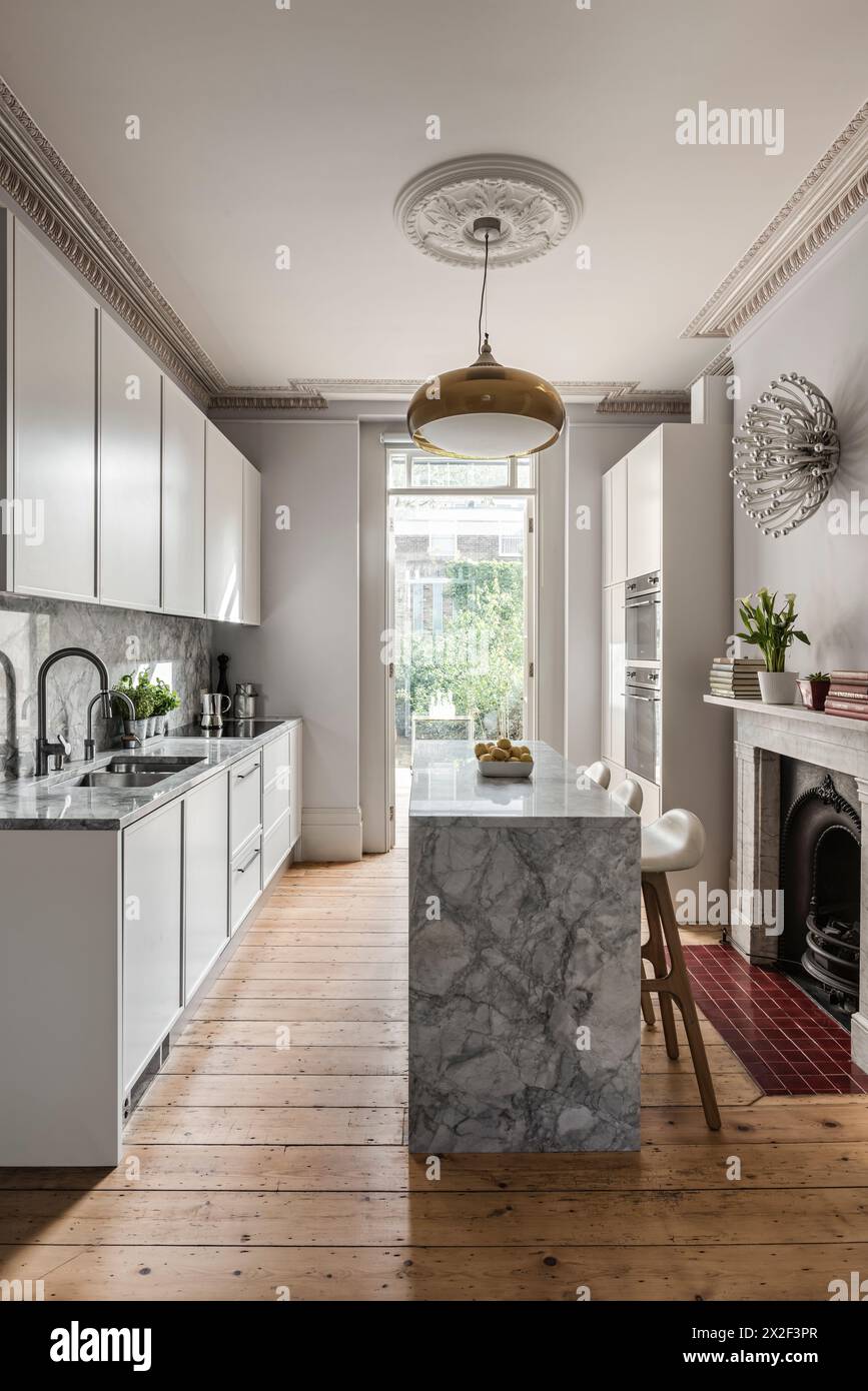 Cucina pulita ed elegante con piani di lavoro in marmo nella casa cittadina georgiana. Paultons Square, Chelsea, Londra, Regno Unito. Foto Stock