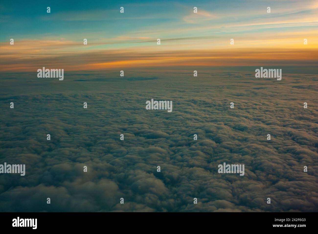 paesaggio nuvoloso dall'alto al tramonto visto da una finestra di un aereo Foto Stock
