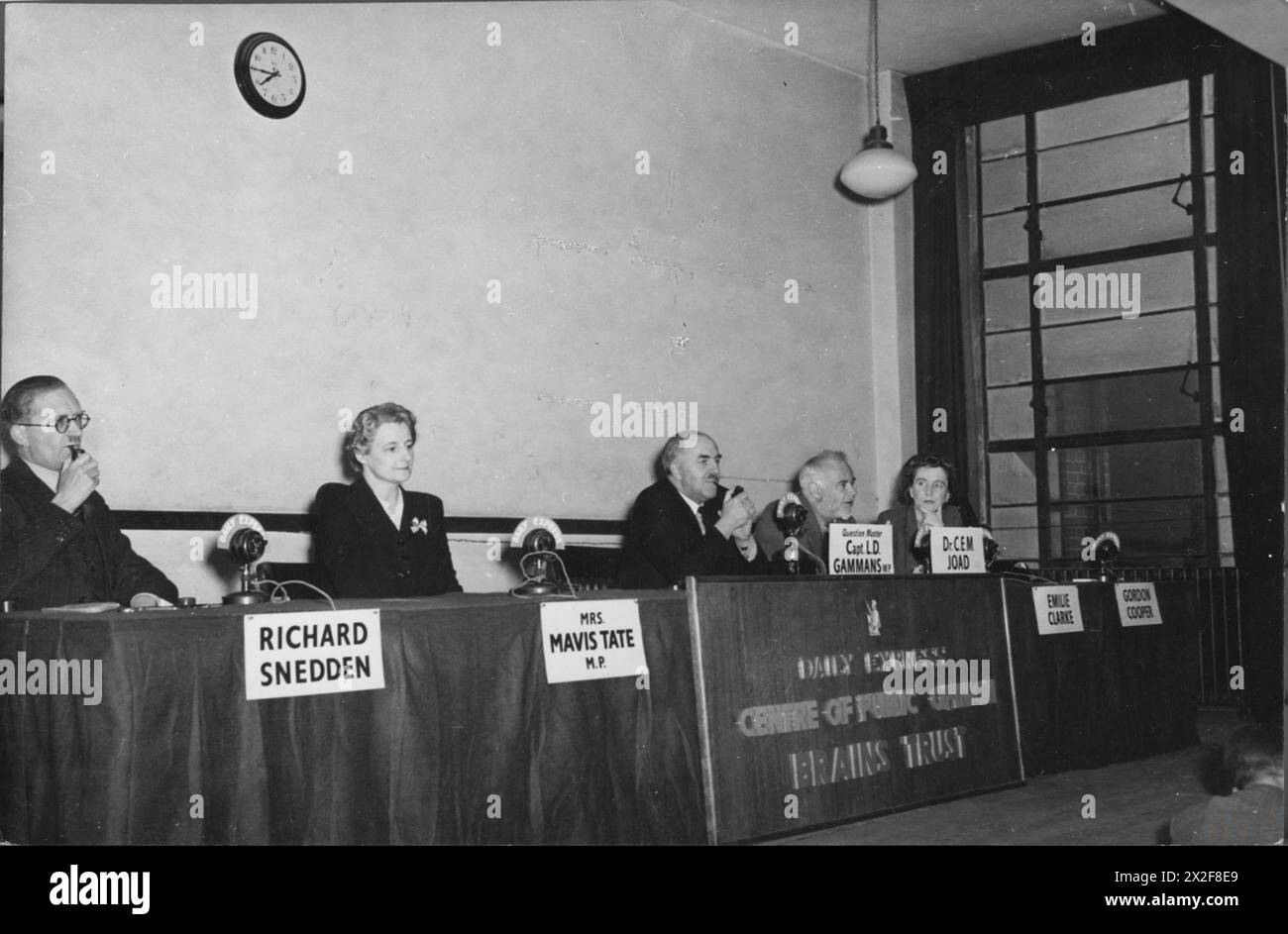 THE DAILY EXPRESS BRAINS TRUST IN SESSION, UK, 1944 - Una visione generale del pannello Daily Express Brains Trust in session. Da sinistra a destra, sono: Richard Snedden (che fuma una pipa), Mrs Mavis Tate, MP, Question Master Captain L D Gammans, MP (che fuma una pipa), Dr C e M Joad (che risponde a una domanda) ed Emilie Clarke. E' pronto un posto per Gordon Cooper, che sembra aver lasciato il tavolo. Un avviso sul fronte del tavolo recita "Daily Express Centre of Public Opinion Brains Trust" Foto Stock