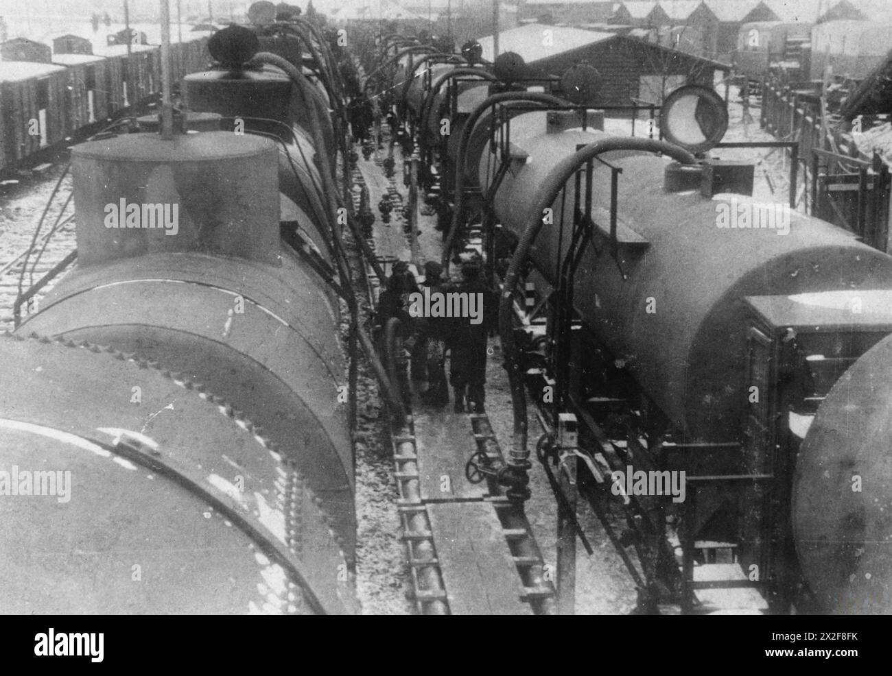 I lavoratori supervisionano il trasferimento di petrolio dalle petroliere sovietiche a quelle tedesche a Przemyśl, Polonia, tra il 1939 e il 1941, garantendo un trasporto agevole nonostante i diversi scarti ferroviari durante la cooperazione nazista-sovietica. Foto Stock
