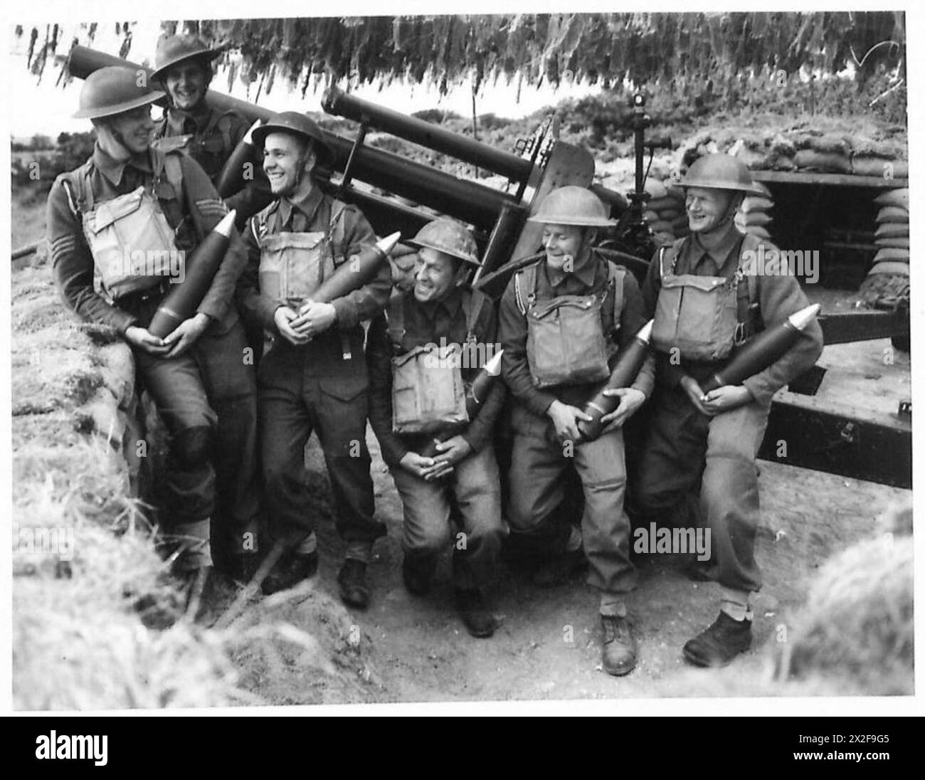 Un equipaggio di cannoni dell'esercito britannico ispeziona i proiettili tedeschi catturati, preparandoli per l'uso contro le ex forze nemiche. Foto Stock