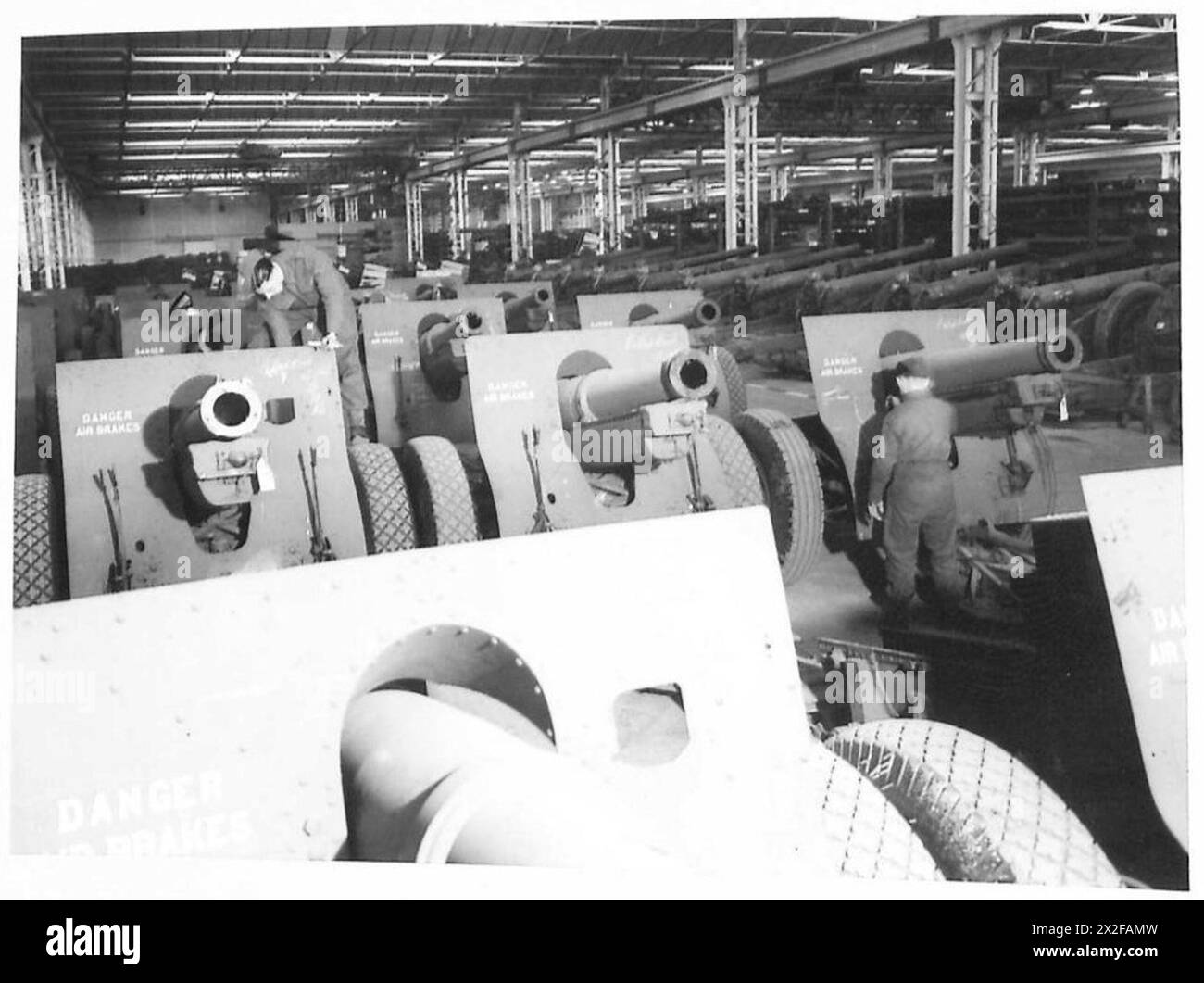 Una fotografia raffigura gli obici da 155 mm forniti sotto forma di Lend-Lease dagli Stati Uniti, conservati in un capannone dell'esercito britannico durante la seconda guerra mondiale per il futuro dispiegamento. Foto Stock