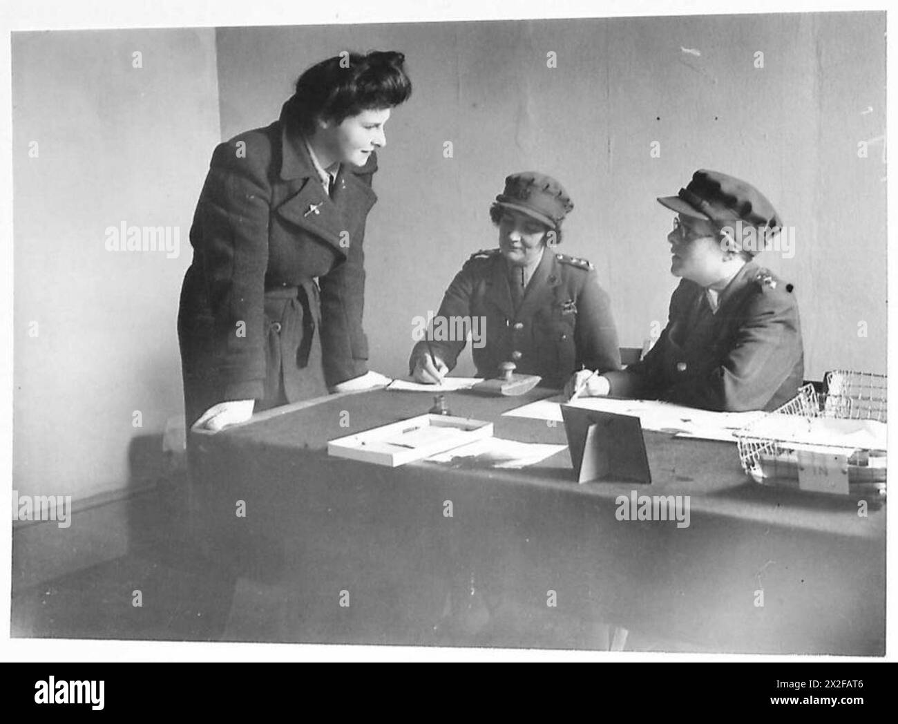 Una fotografia mostra il tenente colonnello W.B.H. Jackson, comandante anziano presso un centro di addestramento dell'A.T.S., intervistando una recluta femminile durante la seconda guerra mondiale, dimostrando il processo di reclutamento e addestramento nel servizio territoriale ausiliario. Foto Stock