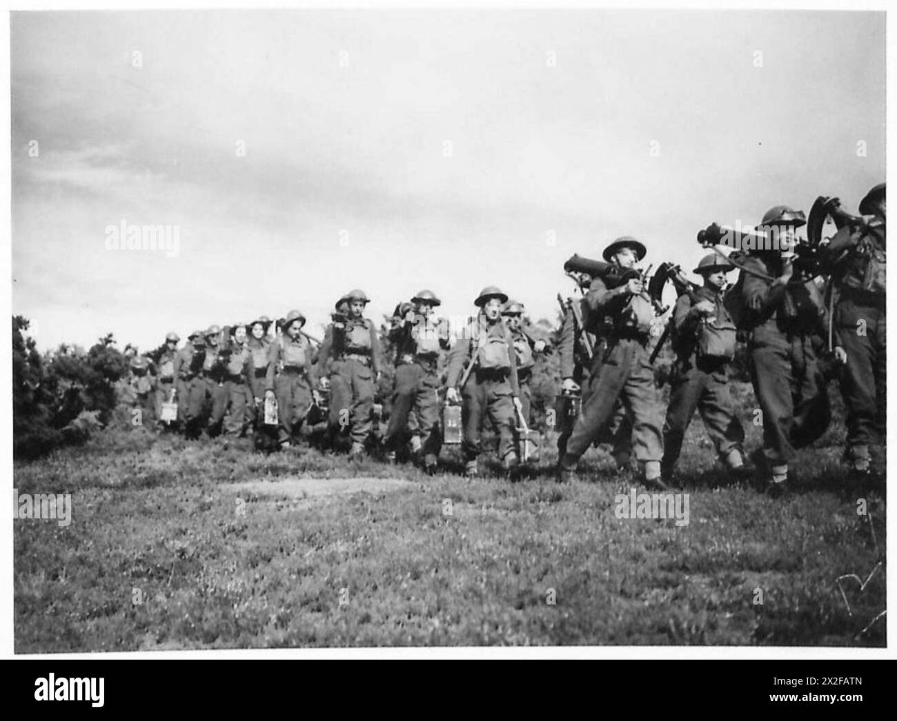 Il 2nd Royal Northumberland Fusiliers marciano su una strada con mitragliatrici smantellate durante un esercizio di addestramento dell'esercito britannico. Foto Stock