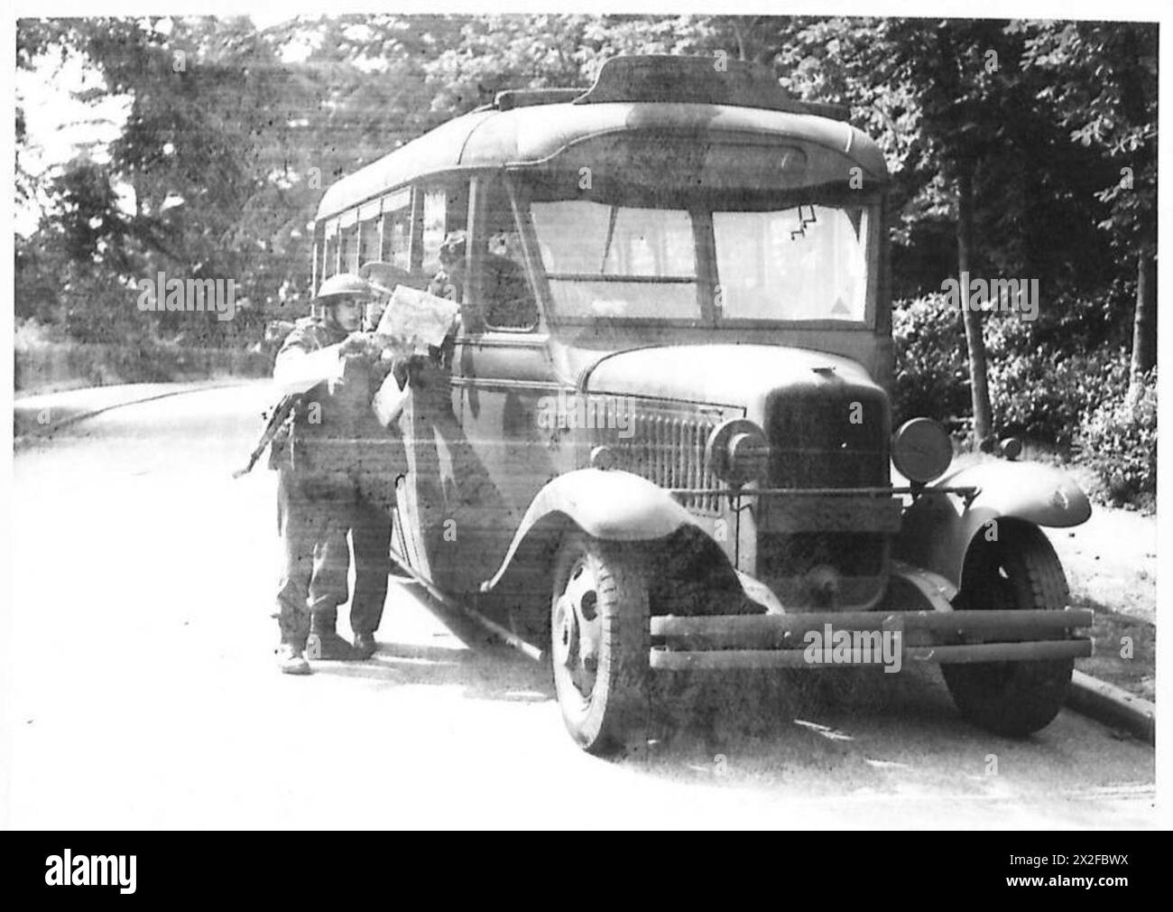 Un membro dell'Aldershot Command Traffic Control Group dirige un autista di autobus militare, gestendo i movimenti dei veicoli per le operazioni dell'esercito britannico. Foto Stock