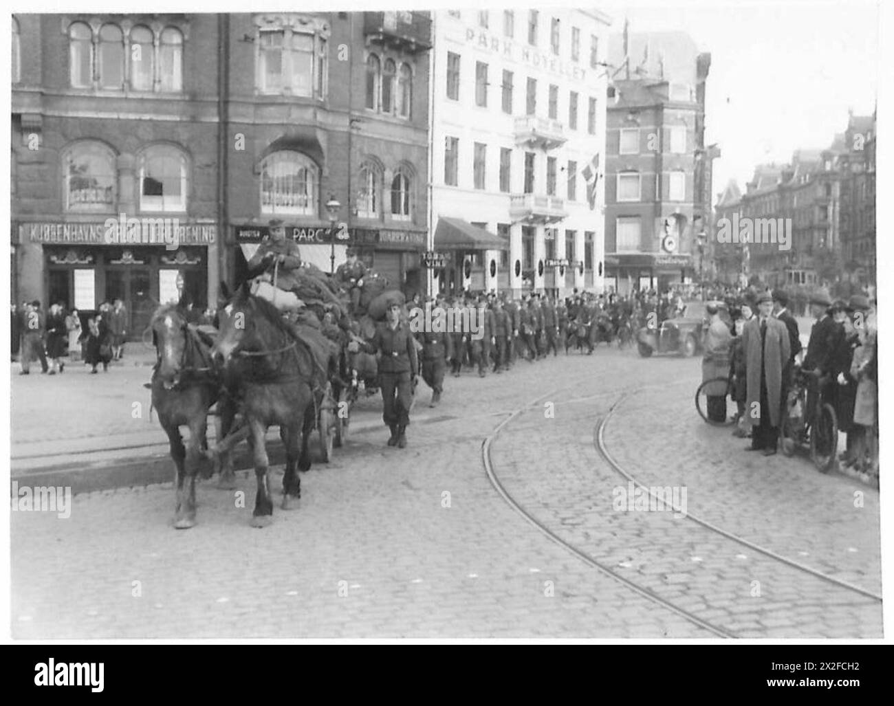 Le truppe tedesche e le donne delle forze armate tornano in Germania attraverso la piazza del Municipio, Copenaghen, utilizzando carri armati midget, biciclette, veicoli trainati da cavalli, e a piedi, osservata dal personale del 21st Army Group dell'esercito britannico. Foto Stock