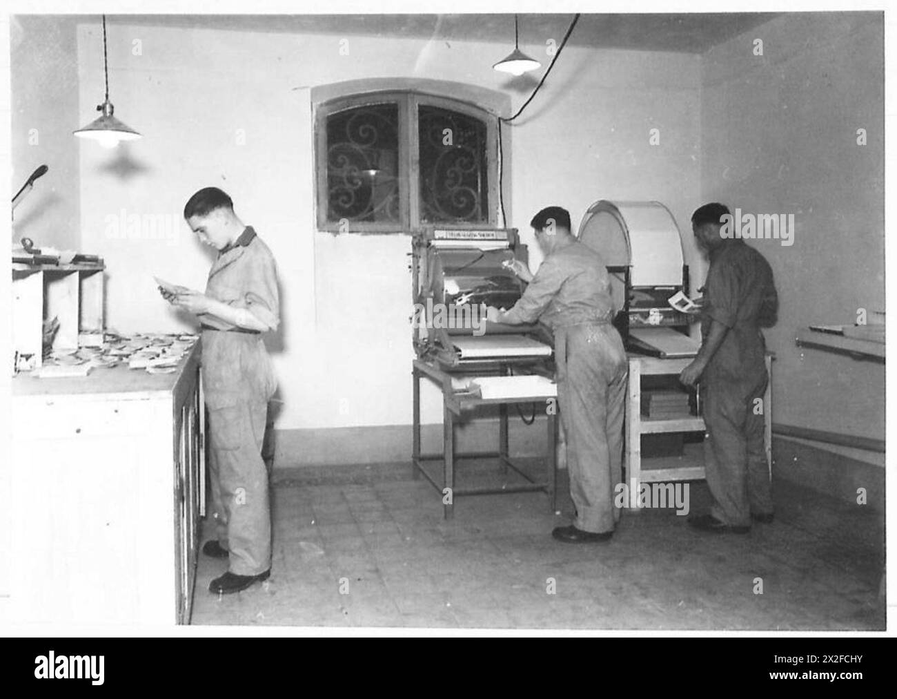 L'Army Film and Photographic Unit elabora le stampe lavandole e smaltandole utilizzando moderne macchine per la vetratura per documentare le attività dell'esercito britannico. Foto Stock
