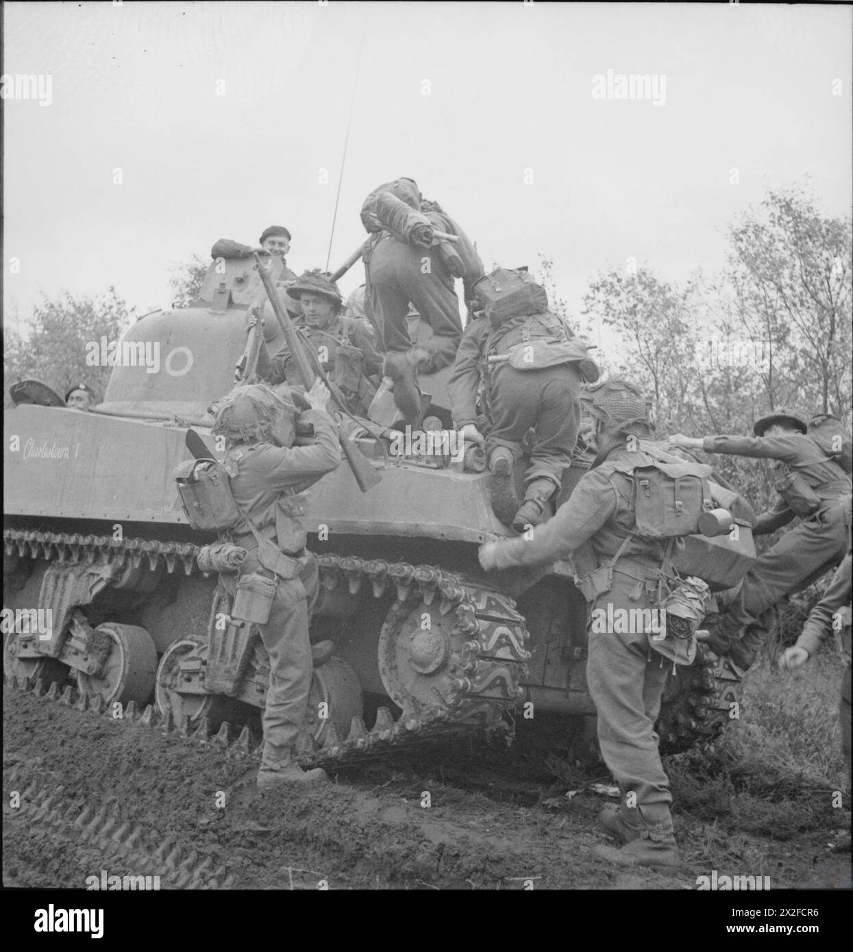 La fanteria dell'esercito britannico sale a bordo di un carro armato Sherman durante l'assalto a Venraij, nei Paesi Bassi, il 17 ottobre 1944 nelle operazioni dell'Europa nordoccidentale. Foto Stock