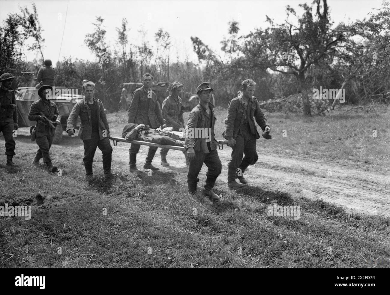 I prigionieri tedeschi portarono un compagno ferito su una barella durante l'offensiva britannica a sud di Caumont in Normandia il 31 luglio 1944. Foto Stock