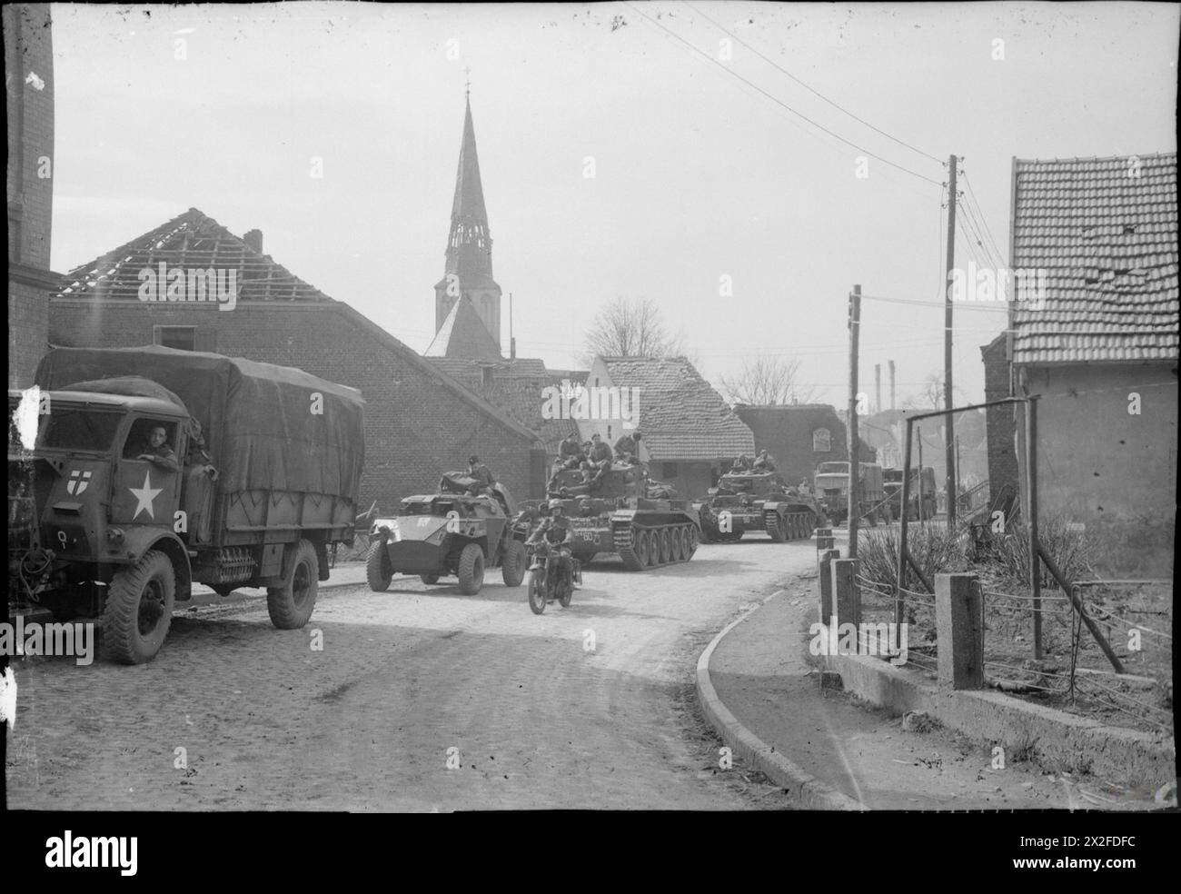 Carri armati Cromwell, auto da ricognizione e camion della 7th Armoured Division britannica avanzarono attraverso Brunen dalla testa di ponte del Reno il 29 marzo 1945 durante le operazioni nell'Europa nordoccidentale. Foto Stock