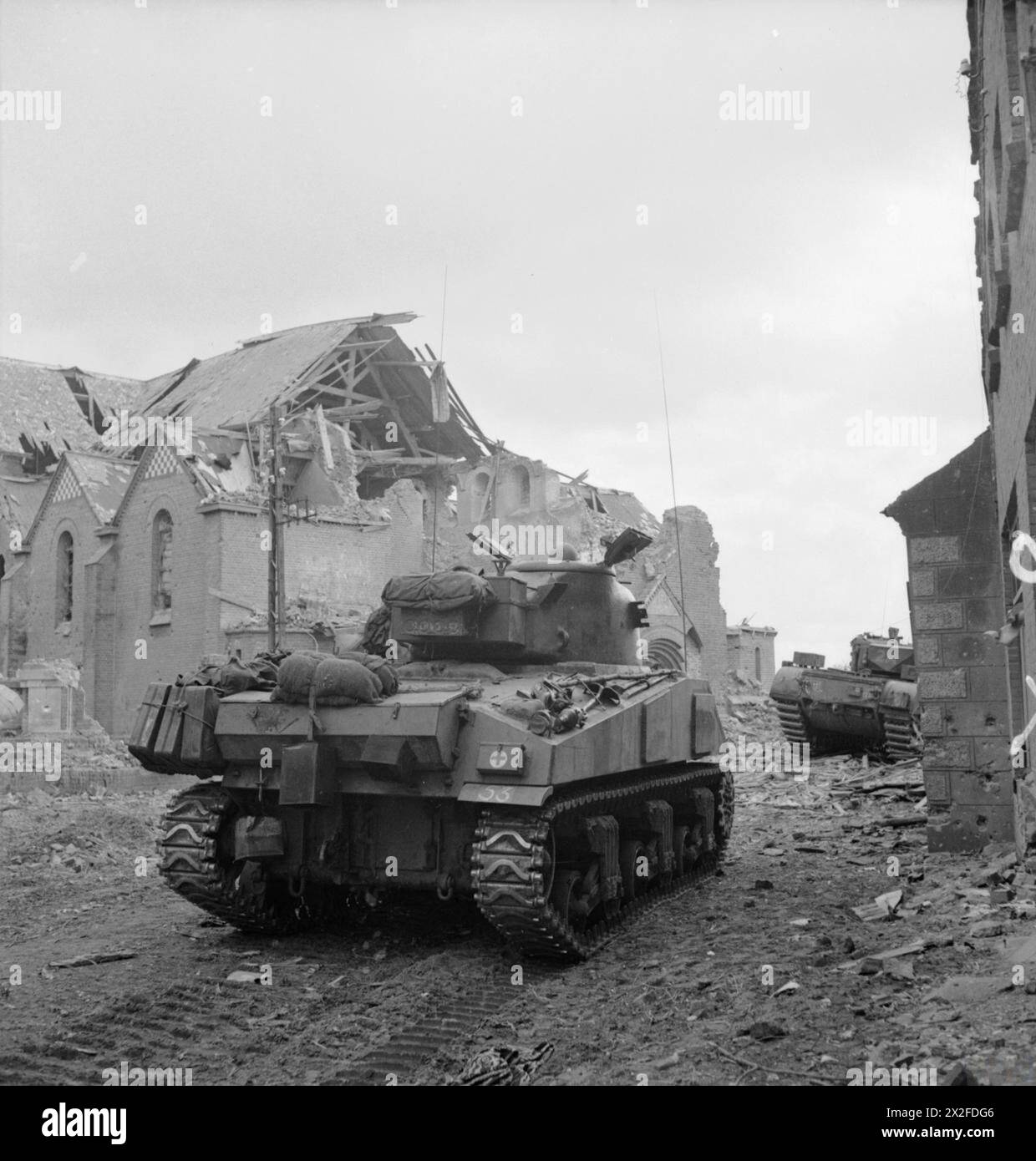 I carri Sherman e Churchill della 3rd Division britannica avanzarono attraverso Overloon il 14 ottobre 1944 durante un attacco ad una sacca di proprietà tedesca nei pressi della città. Foto Stock