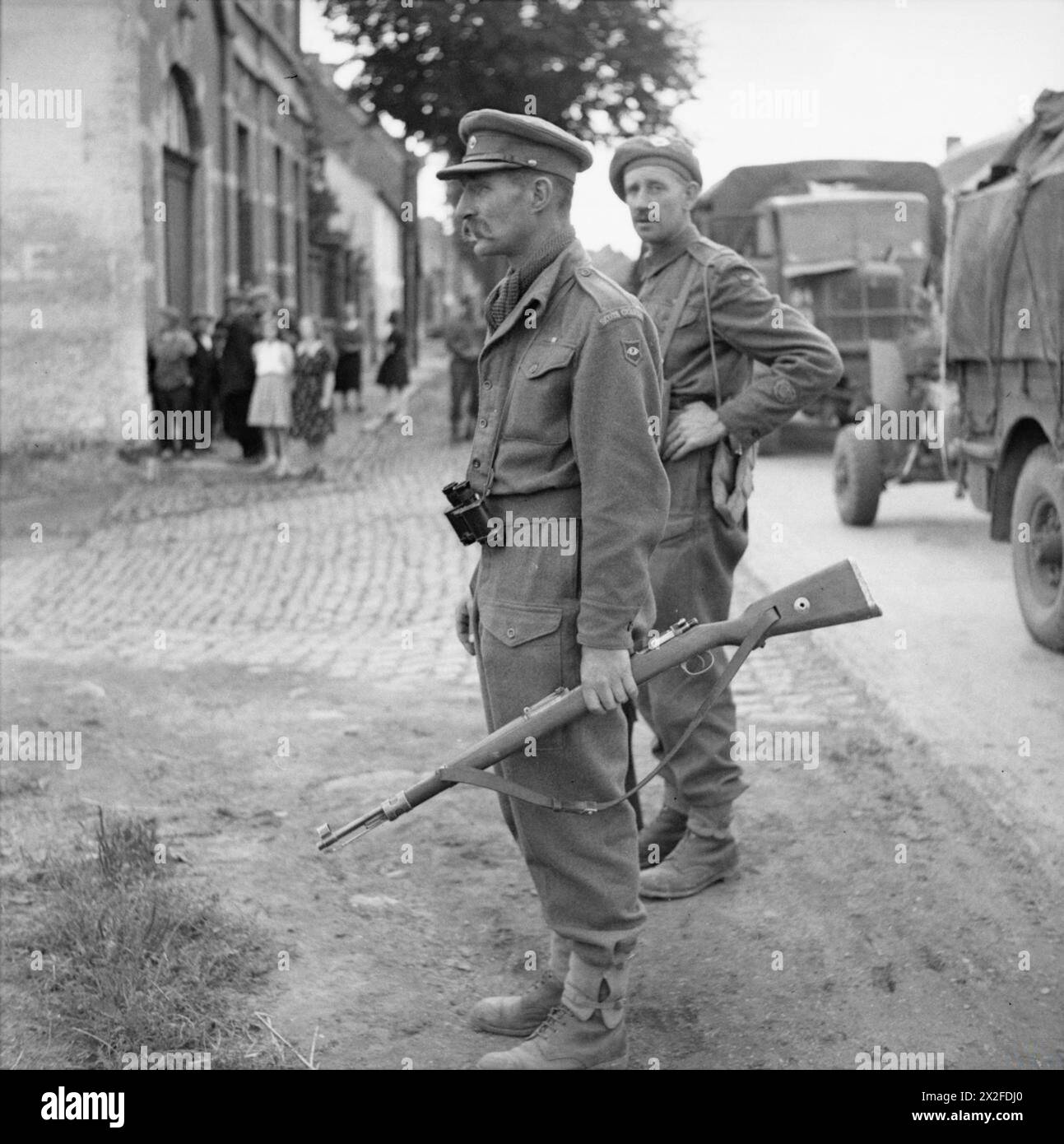 L'ESERCITO BRITANNICO NELL'EUROPA NORDOCCIDENTALE 1944-45 - maggiore Stewart Fotheringham e CSM Low della "X" Company Scots Guards (sotto il comando della 1st Welsh Guards) assistono alle operazioni di pulizia durante l'avanzata a Bruxelles, il 4 settembre 1944. Il maggiore trasporta un fucile tedesco KAR 98 British Army, Scots Guards Foto Stock