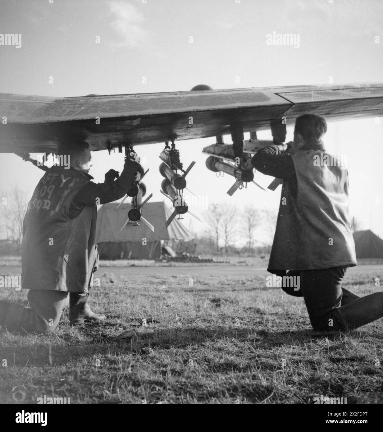 Gli Armourers equipaggiano l'Hawker Typhoon Mark IB MN178 "PR-V" del No. 609 Squadron RAF con ulteriori proiettili a razzo da 60 lb al B77 Gilze-Rijen, Paesi Bassi, durante le operazioni della 2nd Tactical Air Force, 1943-1945. Foto Stock