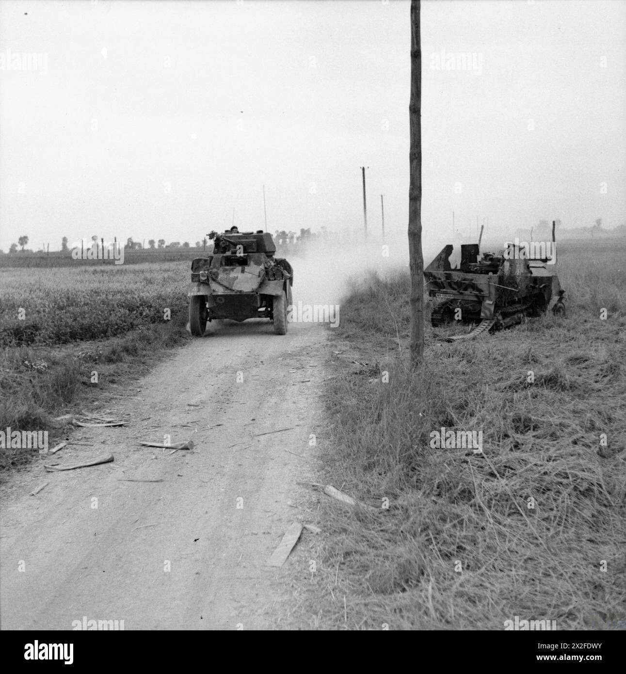 Un'auto corazzata Humber passa davanti a un cannone semovente tedesco da 7,5 cm PaK40 L/46 auf SPW S307(f) distrutto il 19 luglio 1944, una rara conversione basata sui semi-tratte francesi Somua MCG catturati. Foto Stock