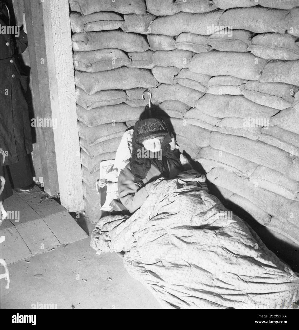 Una donna anziana dorme in un letto improvvisato nel Southwest London Garage Shelter a Pimlico, novembre 1940, con il suo ombrello riposto dietro di lei. Foto Stock