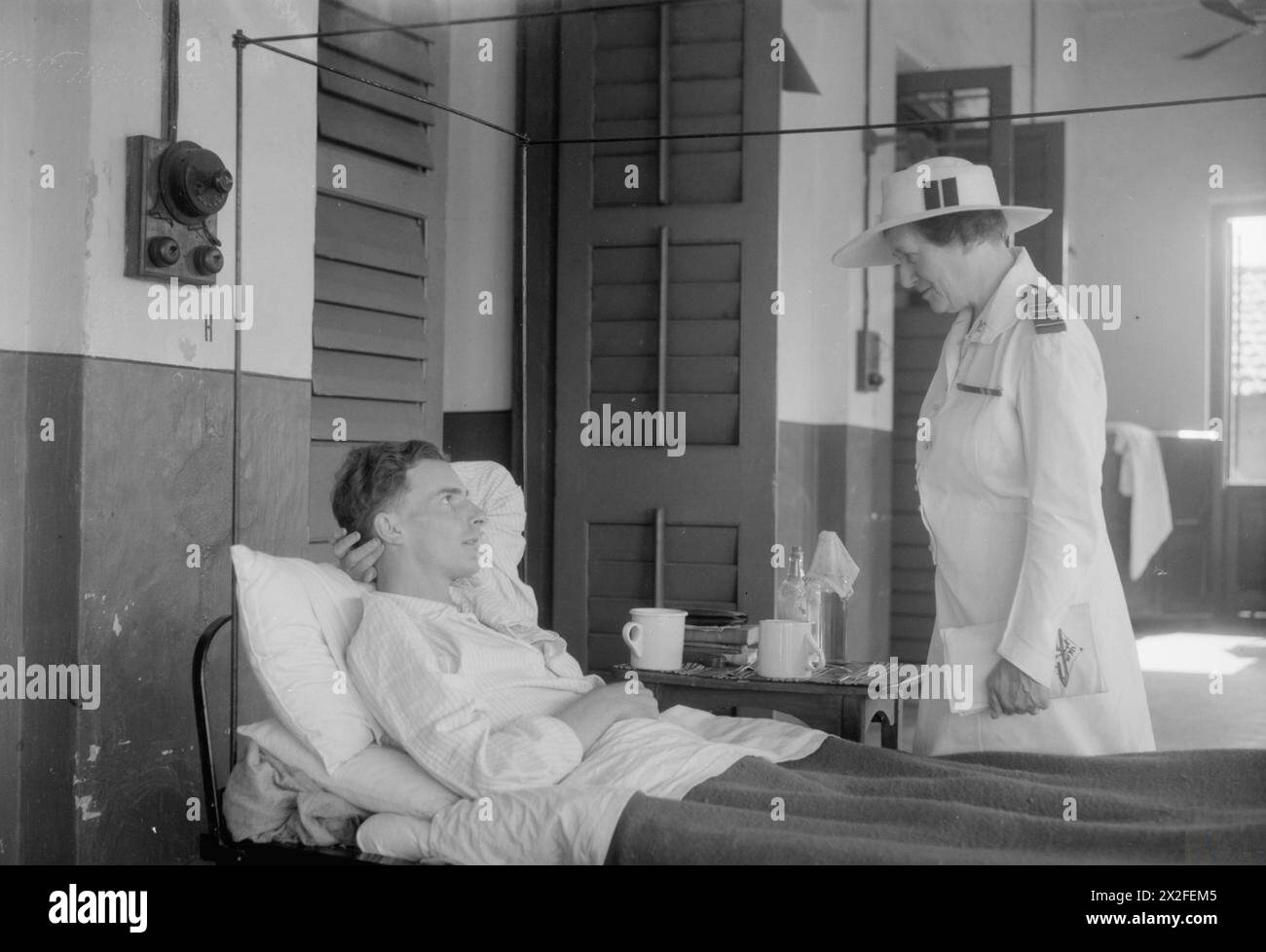 OPERAZIONI DELLA ROYAL AIR FORCE IN ESTREMO ORIENTE, 1941-1945. - Il capo principale della RAF, W M Coulthurst, parla con un paziente dell'ospedale RAF di Calcutta, India, il capo dell'Aircraftman G W Scott di Manchester, durante il suo tour di ispezione nel teatro Foto Stock