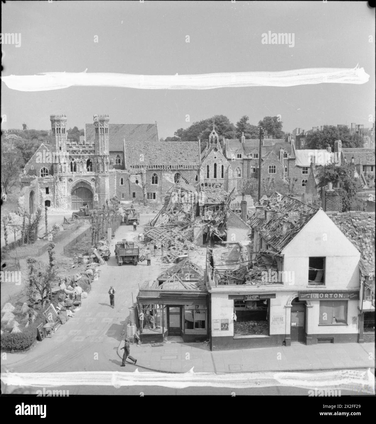 L'abbazia di St Augustine e gli edifici circostanti a Canterbury, nel Kent, sono stati pesantemente danneggiati a seguito di un raid dei Baedeker del 1942. Legname, detriti e negozi parzialmente distrutti sono visibili, con un camion di recupero al centro. Foto Stock