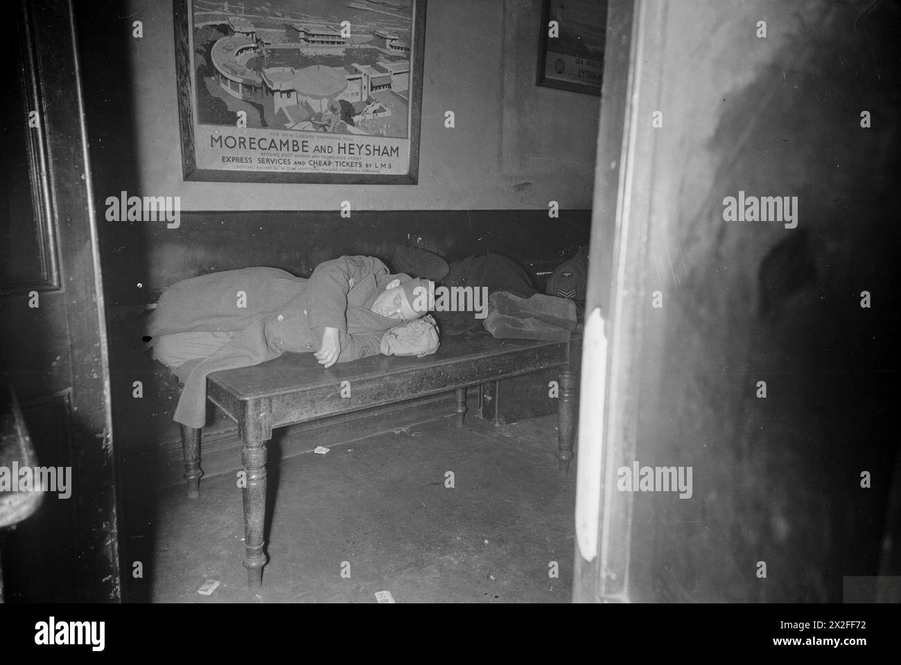 Un sergente americano riposa su un tavolo della sala d'attesa alla stazione ferroviaria di Crewe, un importante nodo ferroviario nel nord-ovest dell'Inghilterra, durante la seconda guerra mondiale, intorno al 1944. Foto Stock