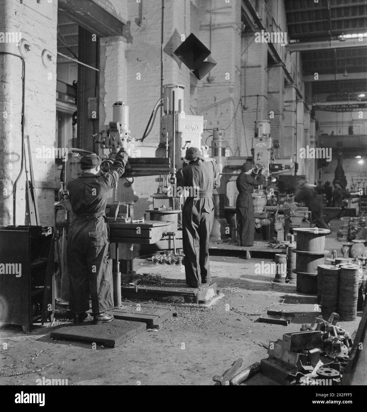 Le lavoratrici di metalli praticano componenti in ottone per motori marini utilizzando trapani a braccio radiale Pollard e Kitchen & Wade durante la seconda guerra mondiale in Gran Bretagna. Foto Stock