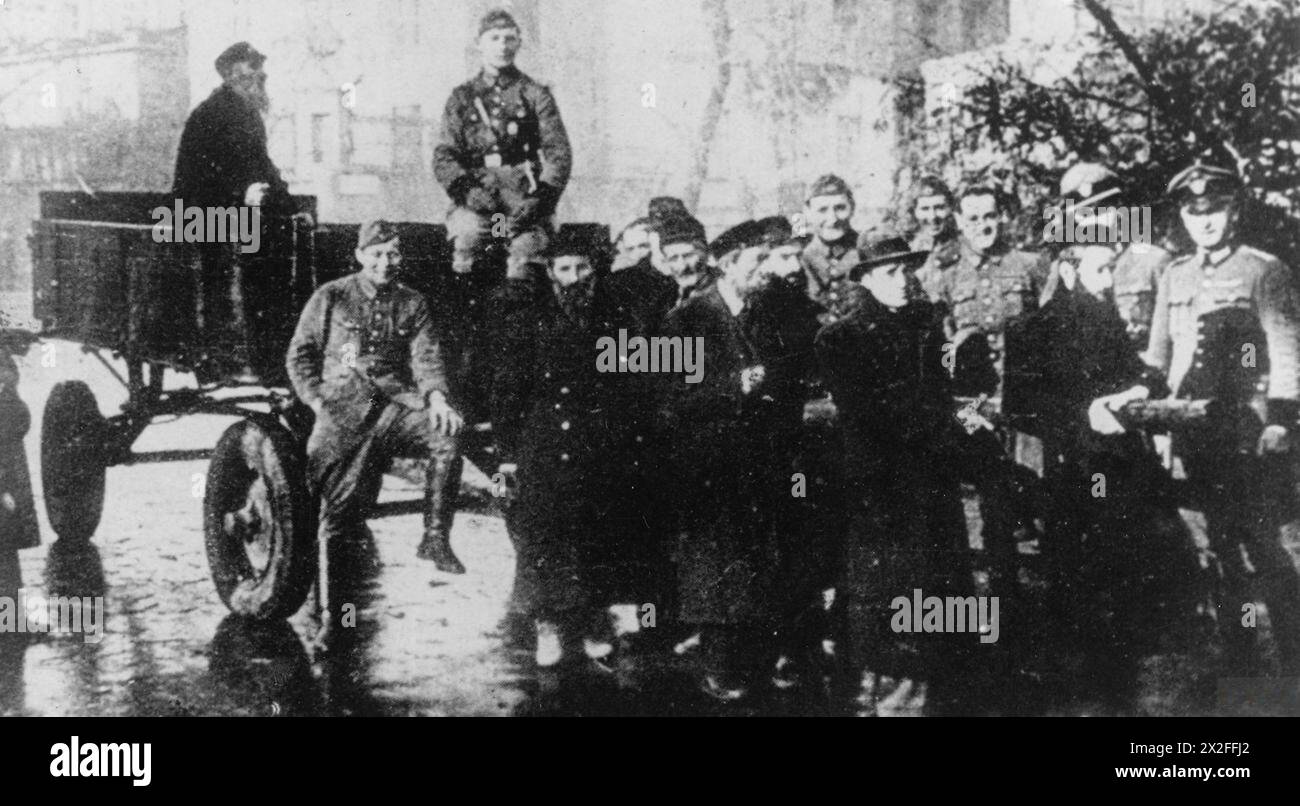 Durante l'occupazione tedesca-sovietica della Polonia, si vedono soldati tedeschi che costringono gli uomini ebrei a Varsavia a tirare i carri mentre sorridono per la macchina fotografica, intorno al 1939-1940. Foto Stock