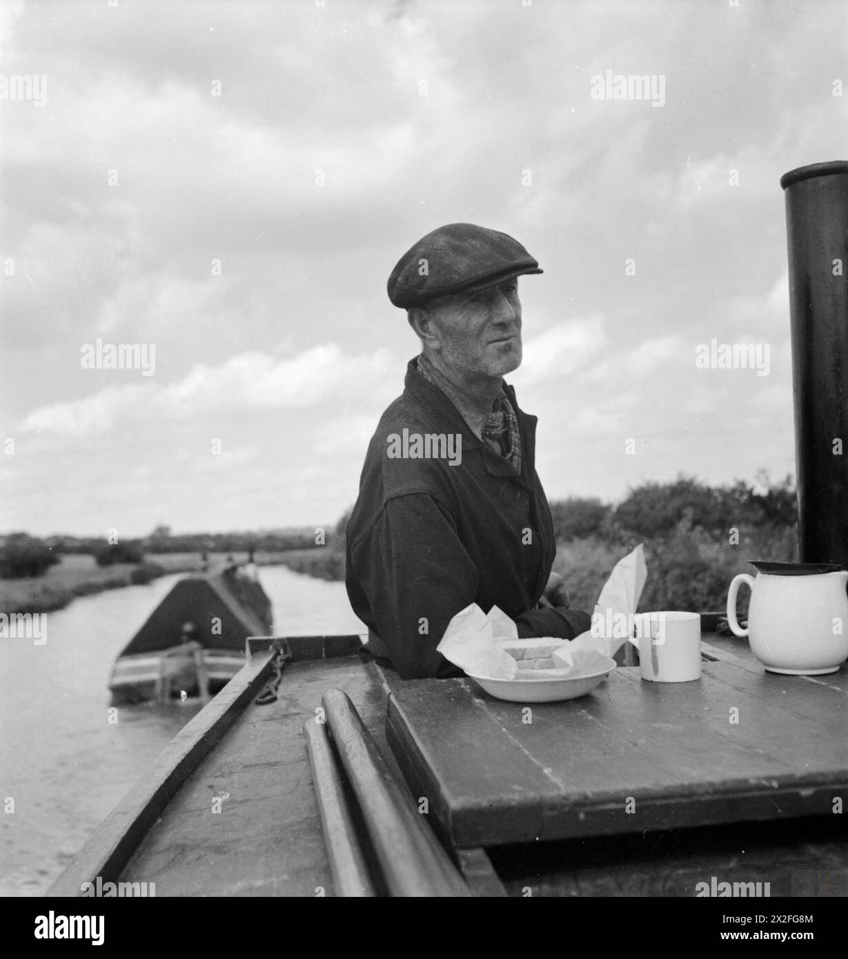 Jack Gribbis pranza mentre guida la sua barca sul Grand Union Canal, 1944. Il "culo" è guidato da sua moglie e sua figlia. Le barche dei canali operano in coppia e sono pagate in base al tonnellaggio trasportato per miglio. Foto Stock