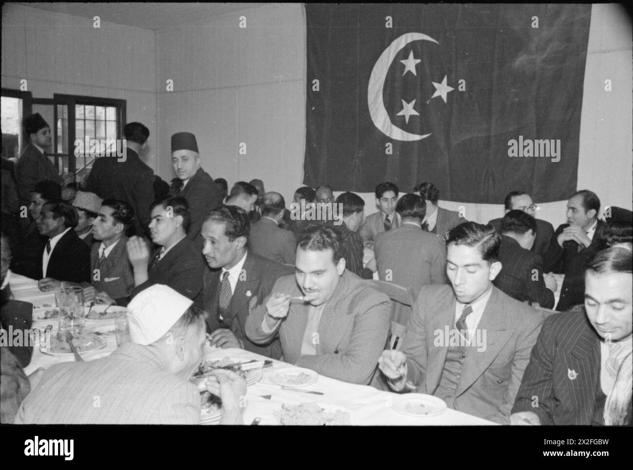 MUSULMANI IN GRAN BRETAGNA: CELEBRAZIONI EID UL FITR, 1941 - Una vista degli uomini che si godono una festa dopo la cerimonia Eid ul Fitr alla Moschea di East London Foto Stock