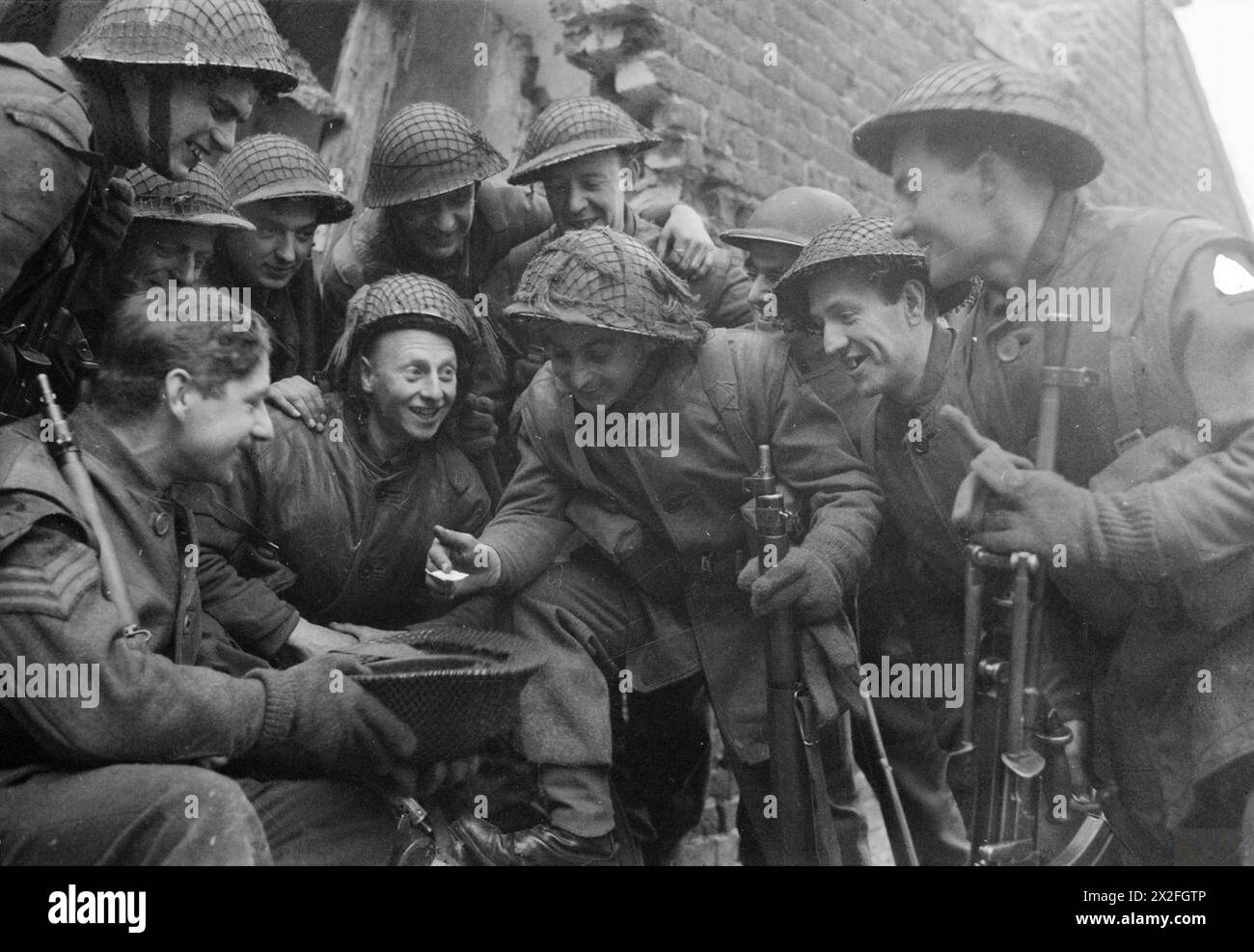 Il soldato W. Allen e gli uomini del 1st South Lancashire Regiment pareggiarono a sorte il 1° gennaio 1945 per determinare il congedo del Regno Unito durante la campagna dell'Europa nordoccidentale del 1944–45. Foto Stock