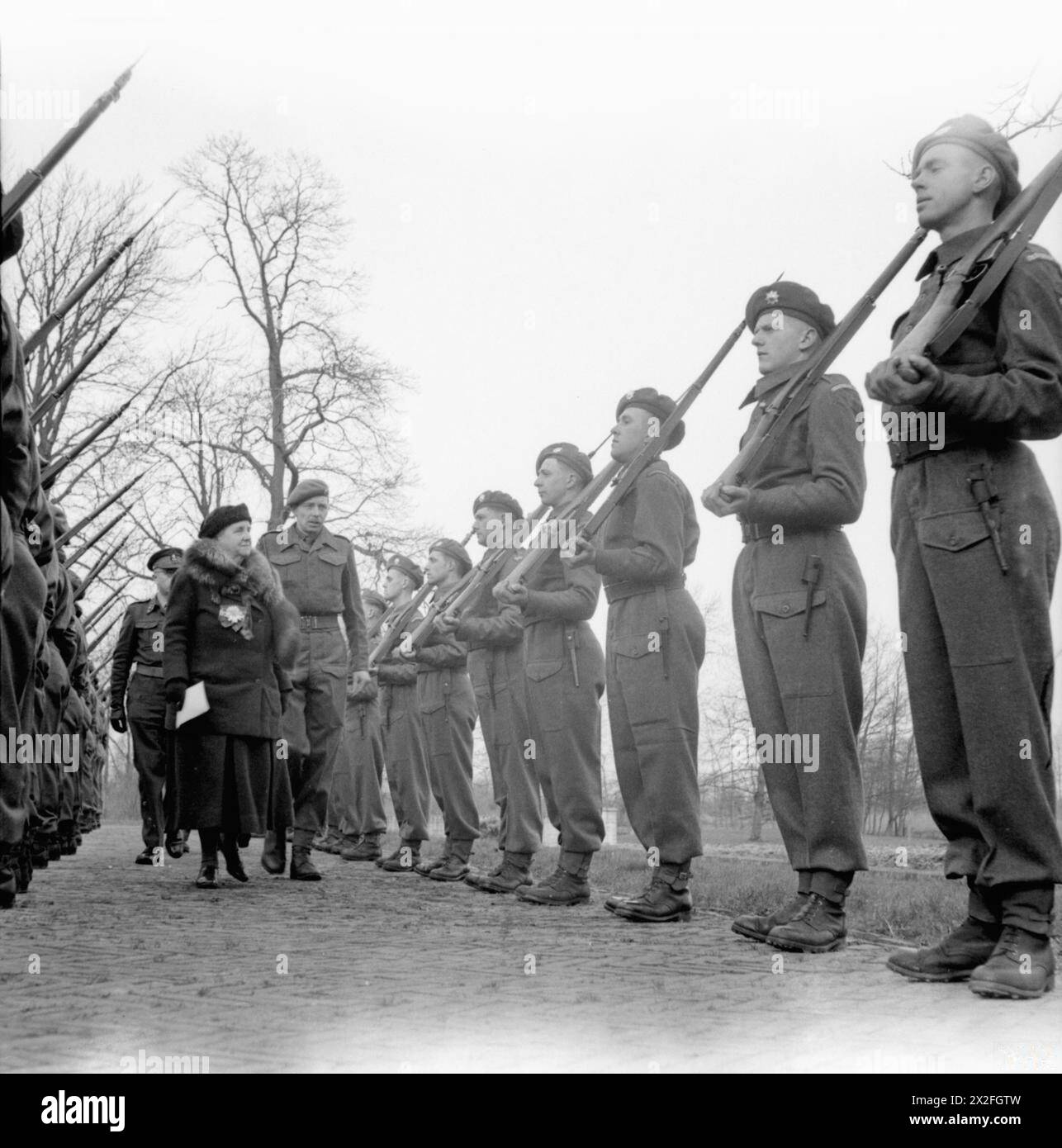 LA FAMIGLIA REALE OLANDESE IN ESILIO DURANTE LA SECONDA GUERRA MONDIALE - HM Regina Guglielmina dei Paesi Bassi ispezionando una Guardia d'Onore, Coldstream Guards, Guards Armoured Division a Nunen, vicino Eindhoven, durante la sua visita in parti liberate dell'Olanda Wilhelmina, Regina dei Paesi Bassi, British Army, Coldstream Guards Foto Stock