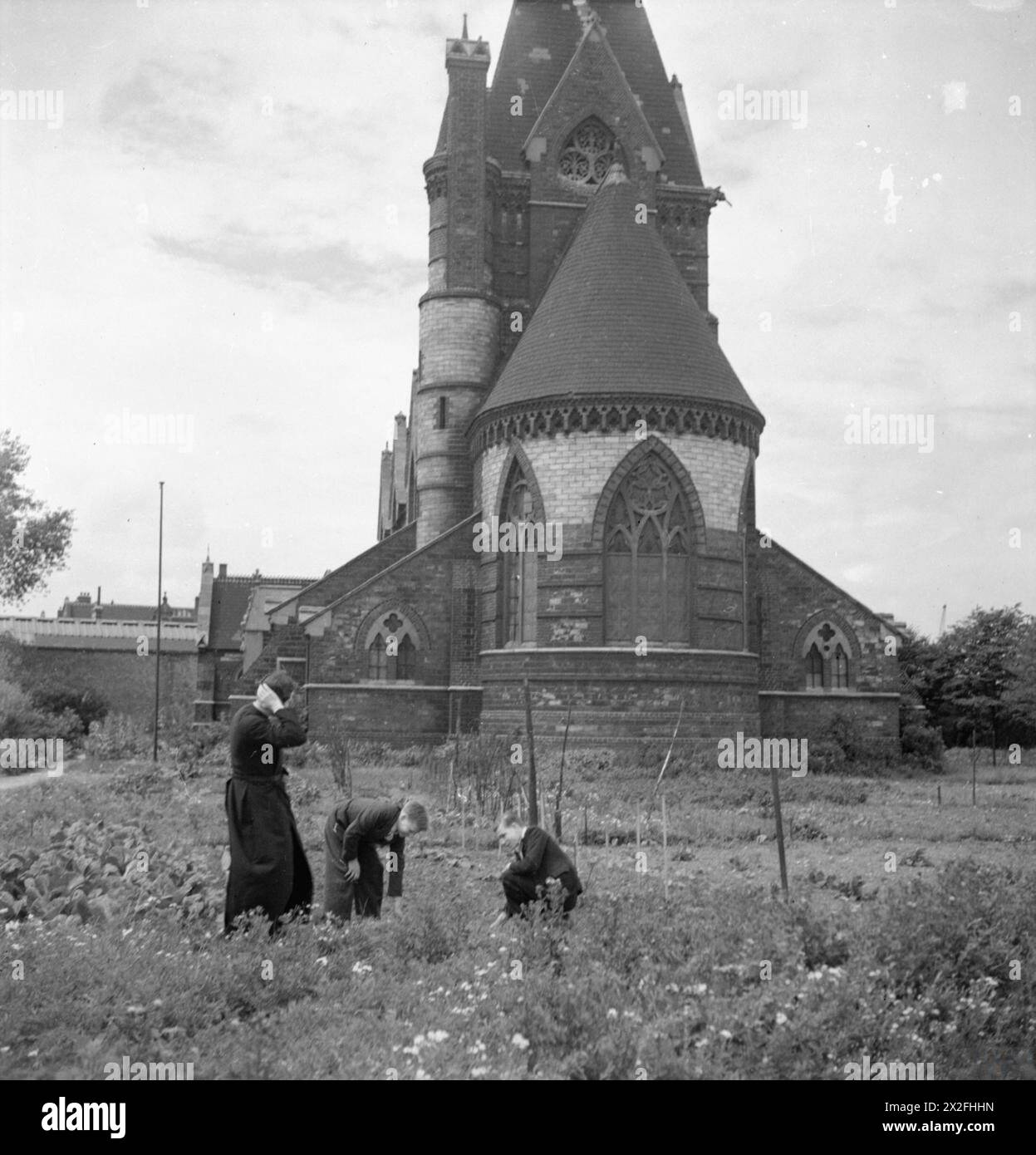 Il reverendo Joseph Stephens supervisiona il lavoro di assegnazione alla chiesa di San Marco, Silvertown, Londra, 1944, dove Stanley e Edward Silvester assistono dopo che il vicariato fu distrutto nel bombardamento del 1940. Foto Stock