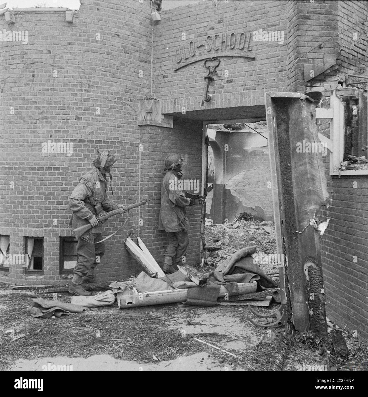 I sergenti J. Whawell e J. Turl del Glider Pilot Regiment cercarono cecchini nella scuola ULO a Kneppelhoutweg, Oosterbeek, durante la battaglia di Arnhem il 21 settembre 1944, parte dell'operazione Market Garden. Foto Stock