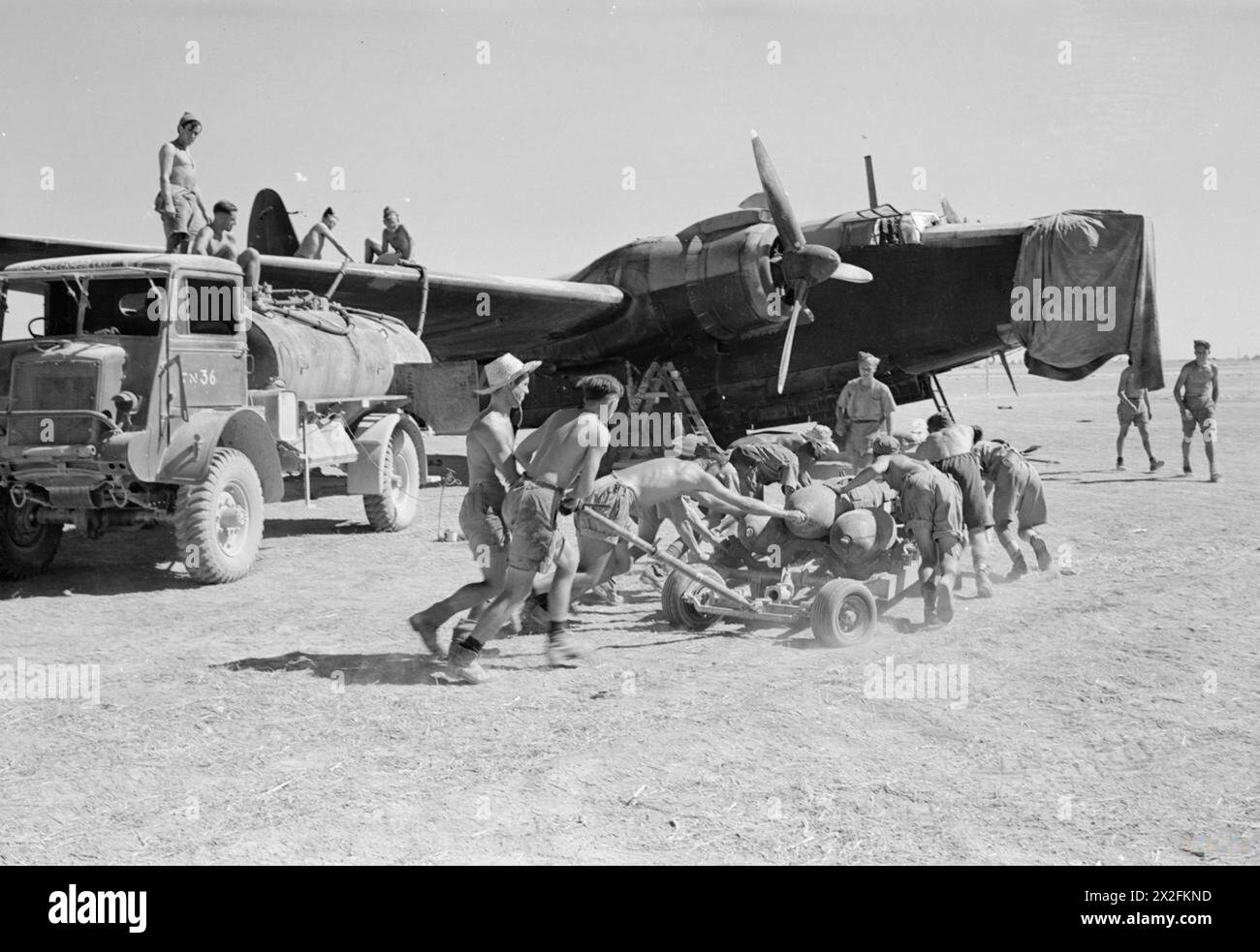 Gli Armourers trasportano un carrello di 500 lb di bombe GP a un Vickers Wellington Mark X del No. 205 Group RAF in un punto di rifornimento in preparazione di un raid notturno sugli obiettivi di Salerno, il giorno prima dell'operazione Avalanche. Foto Stock