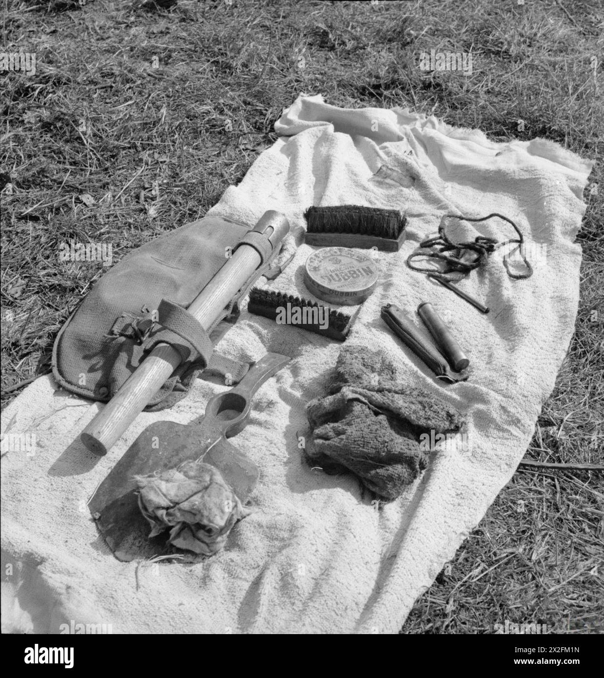 Contenuto di un portautensili trincerato dell’esercito britannico, 1944–1945, compresi utensili trincerati, articoli per la pulizia dei fucili, bottiglia di olio, spazzole e dubbin per la manutenzione. Foto Stock