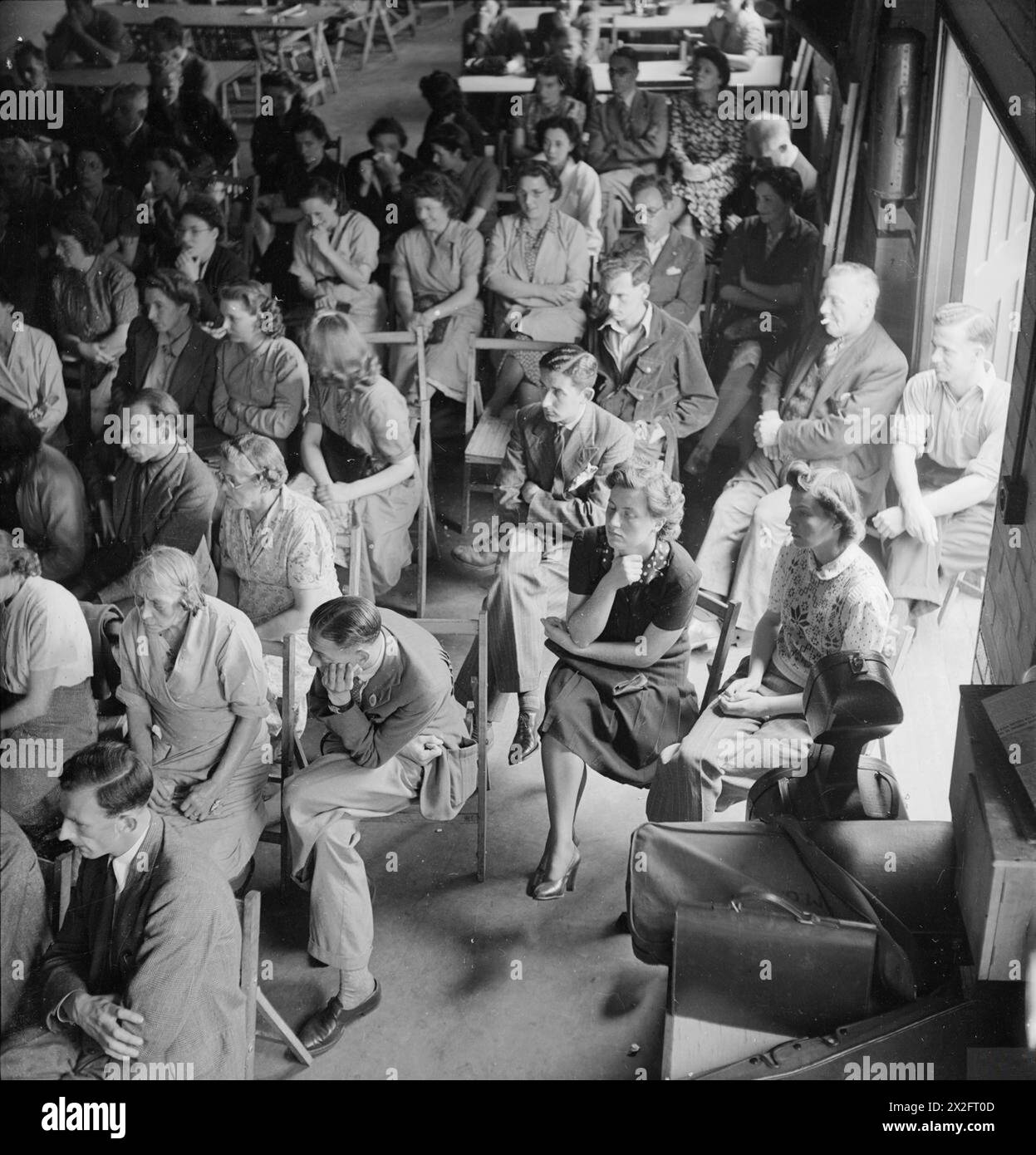 LA MUSICA VA IN GUERRA: INTRATTENIMENTO IN TEMPO DI GUERRA IN GRAN BRETAGNA, 1943 - un pubblico di operai di guerra in una fabbrica di aerei, da qualche parte in Gran Bretagna, ascolta l'Hirsch String Quartet (non nella foto) mentre suonano un quartetto in e Flat di Dittersdorf durante un concerto a pranzo nella loro mensa Foto Stock