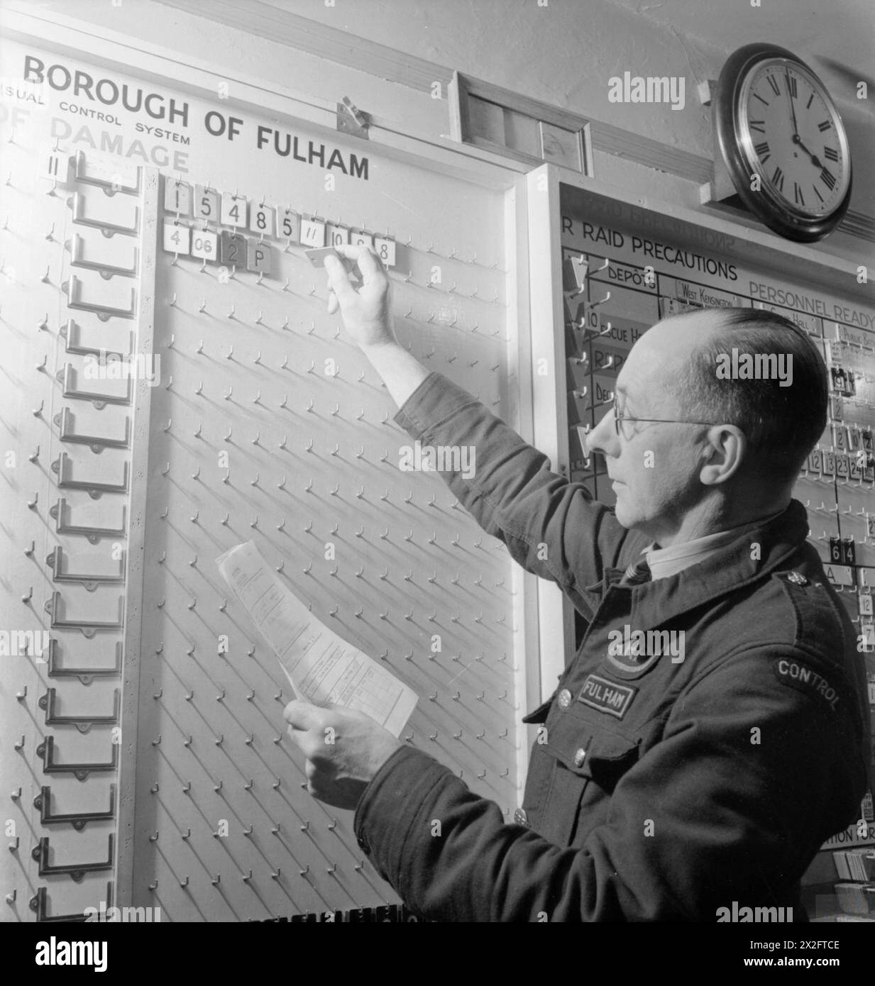 Durante la formazione per la difesa civile a Fulham, Londra, nel 1942, l'addetto al comando utilizzò le schede del pannello incidenti per rappresentare i servizi di emergenza che rispondevano a un incidente simulato. Foto Stock