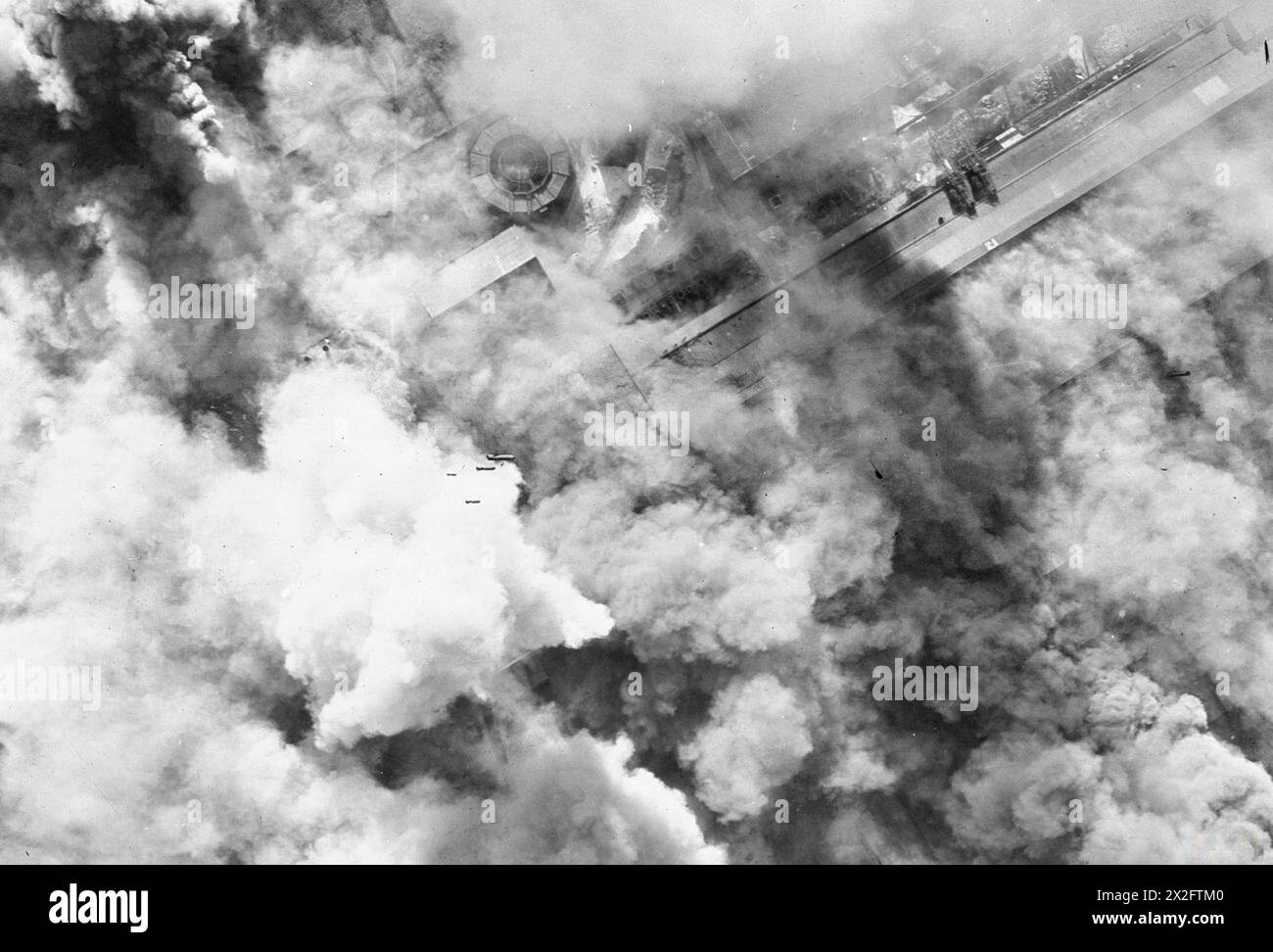 Una fotografia aerea verticale mostra un attacco alla luce del giorno a basso livello su acciai e armamenti a Denain, in Francia, nel 1943 da Douglas Boston Aircraft dal n. 88, 342 (francese libero) e 107 Squadron RAF, guidati dal Wing Commander G.R. England. Le bombe esplosive producono denso fumo sulla fabbrica di ferro-lega della Societe Francaise de Constructions Mecaniques. Foto Stock