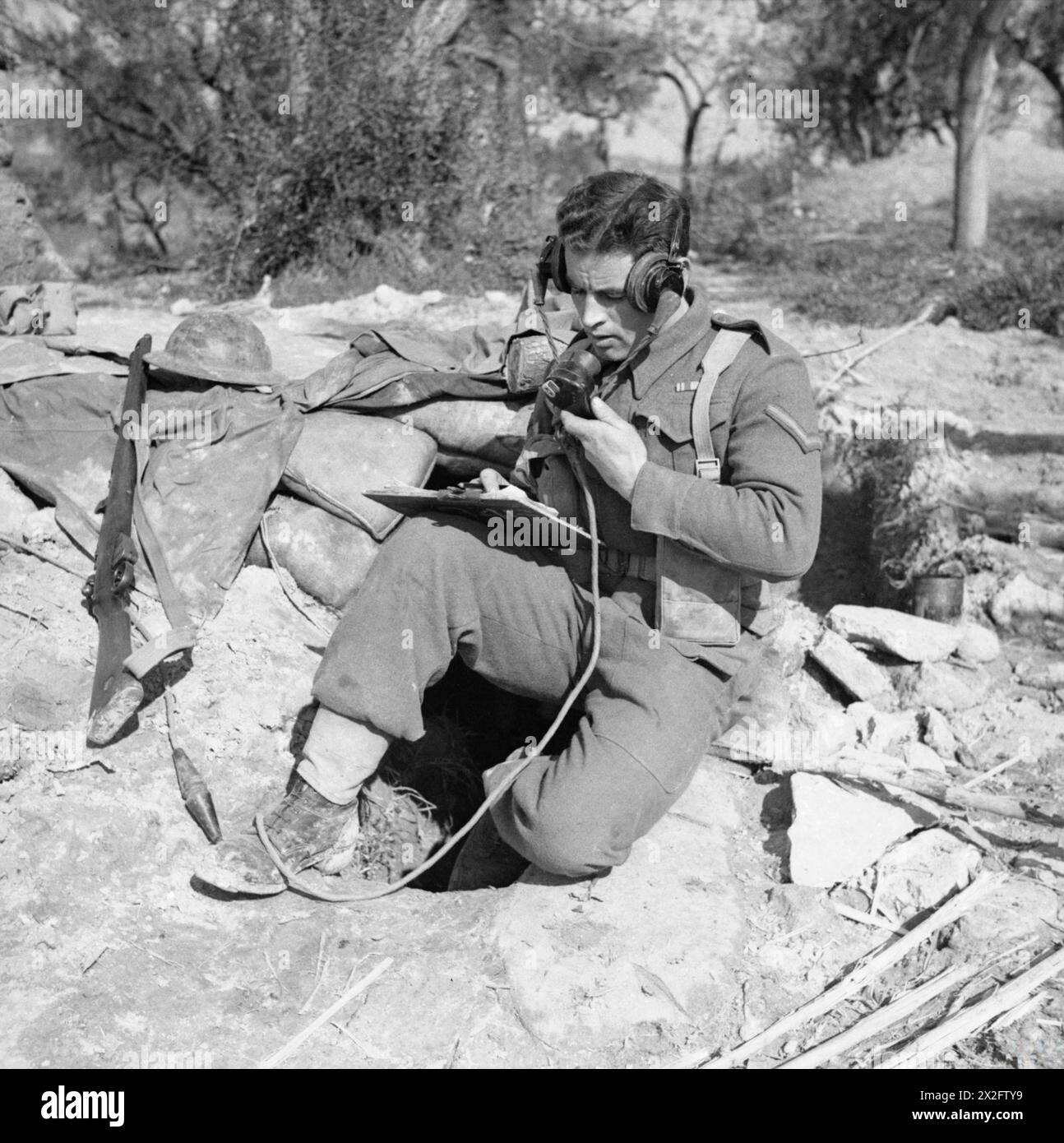La Lance Corporal Rolls of the Royal Signals utilizza un set wireless per trasmettere un ordine di fuoco ad una batteria di cannoni in Italia il 4 marzo 1944. Foto Stock