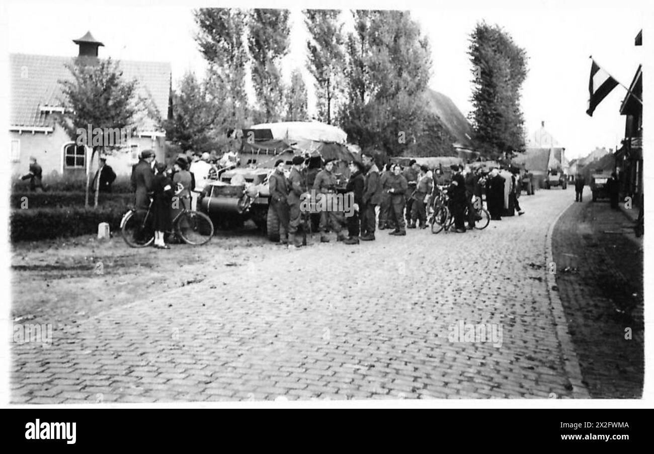 I residenti di Dirschot si riuniscono vicino a un veicolo Reece nel centro del villaggio dopo la liberazione da parte delle forze dell'esercito britannico del 21st Army Group. Foto Stock