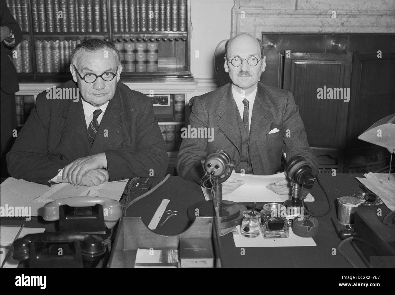 PERSONALITÀ POLITICHE BRITANNICHE 1936-1945 - The Attlee Administration 1945 - 1951: Il primo ministro Clement Attlee (a destra) e il ministro degli Esteri Ernest Bevin fotografarono al 10 di Downing Street alla mezzanotte del 14 agosto 1945. Avevano appena annunciato, in un discorso trasmesso alla Gran Bretagna e all'Impero, la notizia della resa giapponese Attlee, Clement Richard, Bevin, Ernest Foto Stock