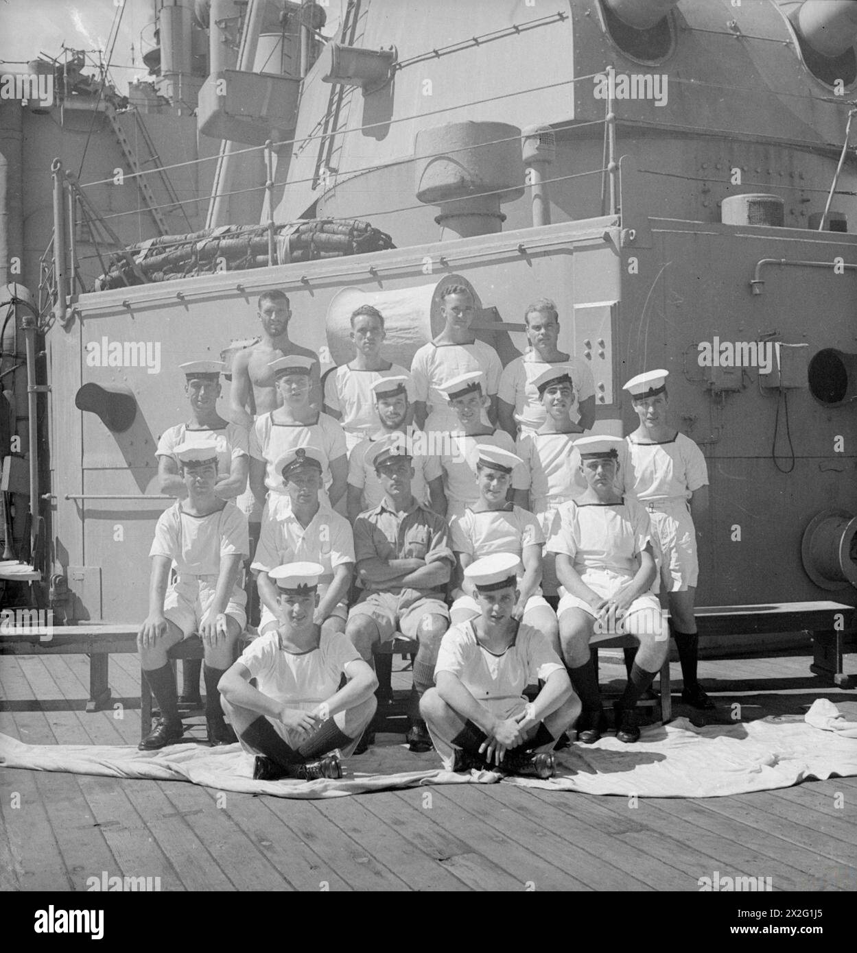 UOMINI DELLA HMS SUFFOLK, UN INCROCIATORE CHE SERVE CON LA FLOTTA ORIENTALE DELL'AMMIRAGLIO JAMES SOMERVILLE. 12 DICEMBRE 1943, TRINCOMALEE. GLI UOMINI SONO DIVISI IN GRUPPI PER CITTÀ E/O DISTRETTO. - Liverpool e District Group. Prima fila, da sinistra a destra: J Mulvihill, Birkenhead; J MacKenzie, Kirkdale. Seconda fila, da sinistra a destra: L Owens, Kirkdale; H Eastwood, Whiston; T Burdell, Southport; R Boodle, GT Crosby; V Kelly, St. Helens. Terza fila, da sinistra a destra: C Oliver, Kensington; M Fitzgerald, Toxeth; J Fisher, Warrington; J Coulthard, Kirkdale; M Murphy, Kirkdale; prezzo B, St. Helens. Quarta fila, da sinistra a destra: J Eve Foto Stock