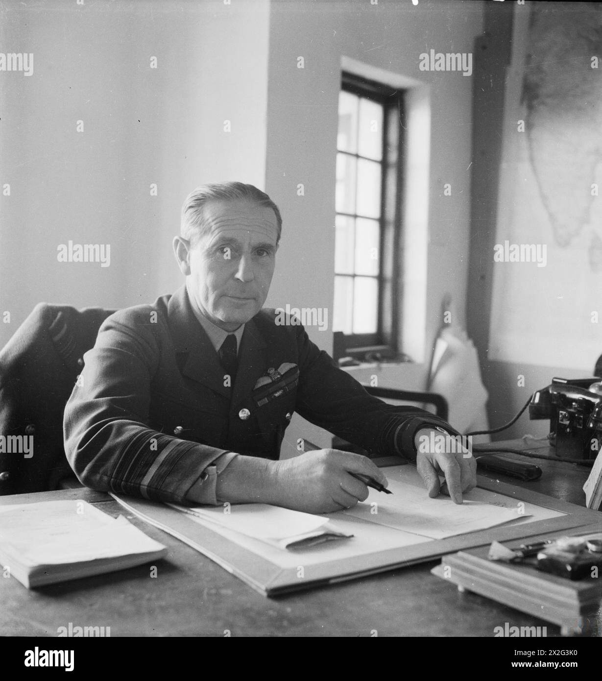 CECIL BEATON PHOTOGRAPHS: POLITICAL AND Military Personalities: Half length portrait of Air Chief Marshal Philip Joubert de la Ferte, Vice Capo di Stato maggiore per l'informazione e gli affari civili, South East Asia Command, seduto alla sua scrivania Joubert de la Ferte, Philip Bennet Foto Stock