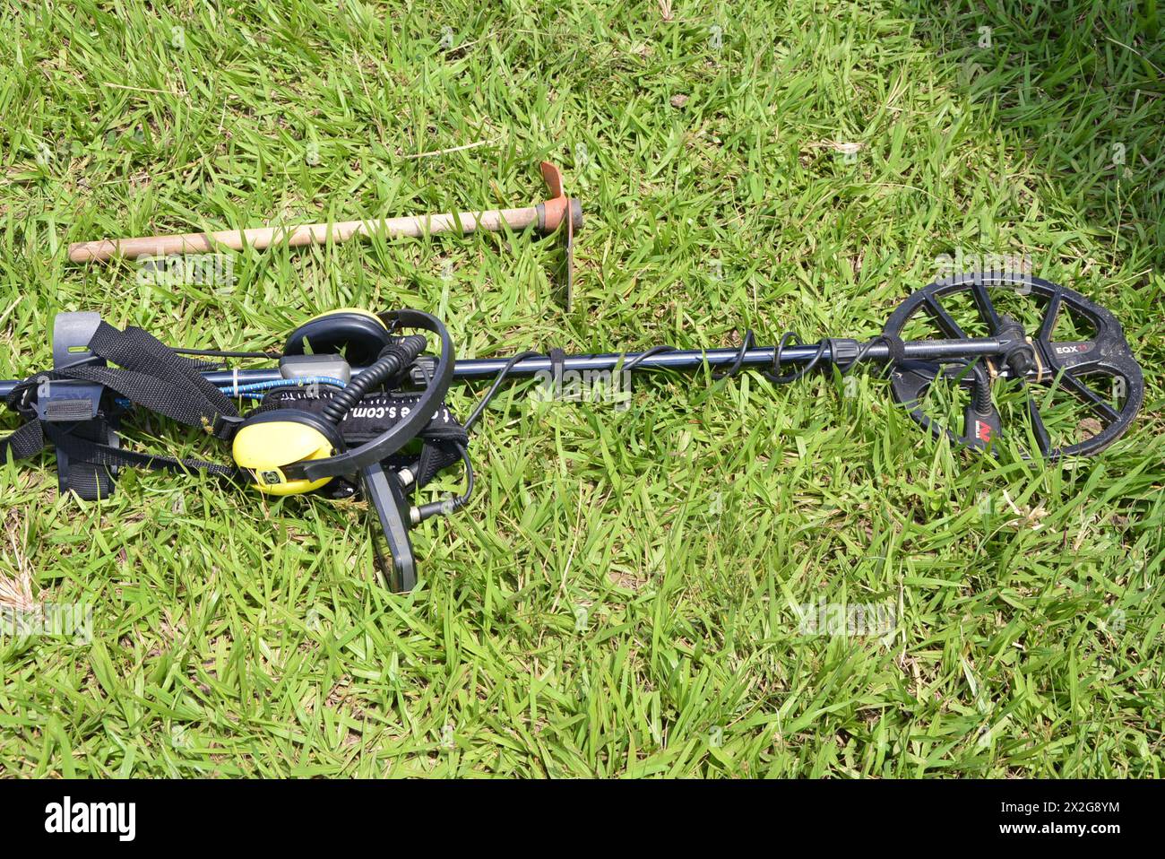 Apparecchiatura di rilevamento utilizzata per trovare materiale sepolto attività di qualcuno che utilizza un metal detector per trovare monete, medaglie, stile caccia al tesoro. Vista dall'alto verso il basso W Foto Stock