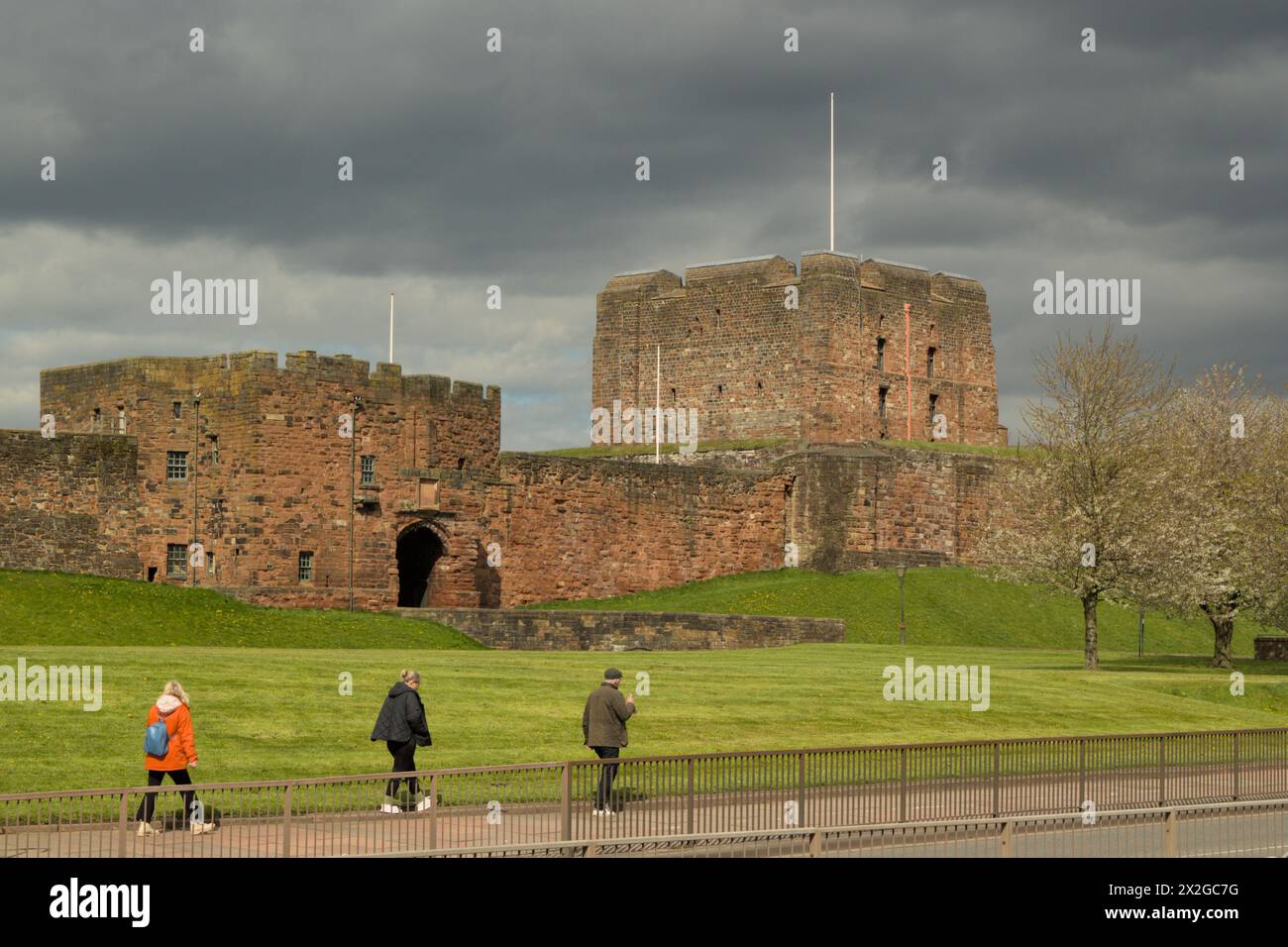 Castello medievale di Carlisle e fortezza in una luminosa giornata primaverile con persone che camminano accanto. Carlisle, Cumbria, Regno Unito Foto Stock