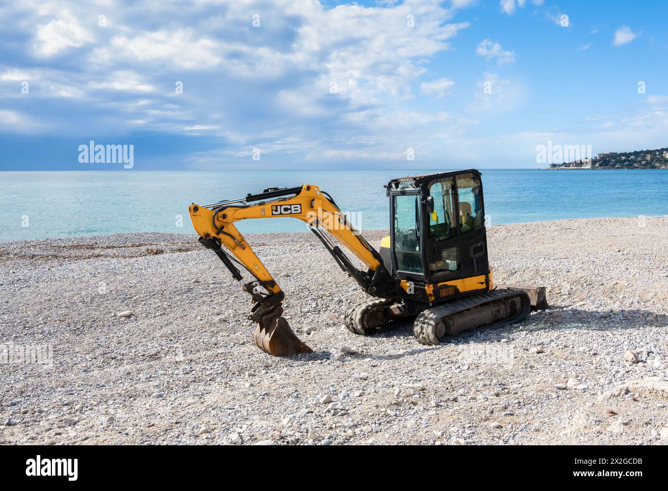 Mentone, Francia - 9 aprile 2024: L'escavatore dell'azienda JCB sulla spiaggia di Mentone. Foto Stock