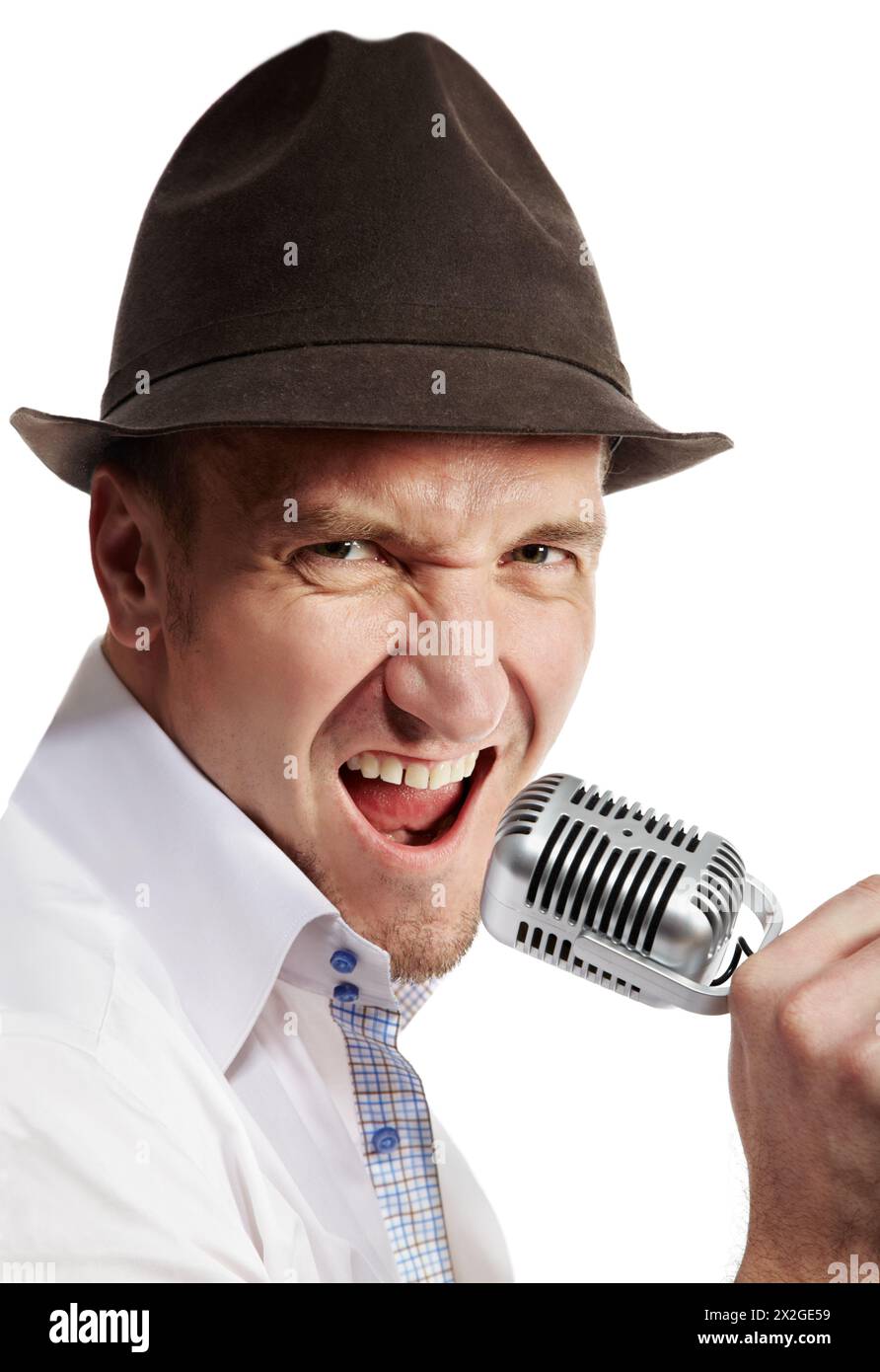 L'uomo con il cappello marrone in feltro canta in modo espressivo nel microfono. Foto Stock