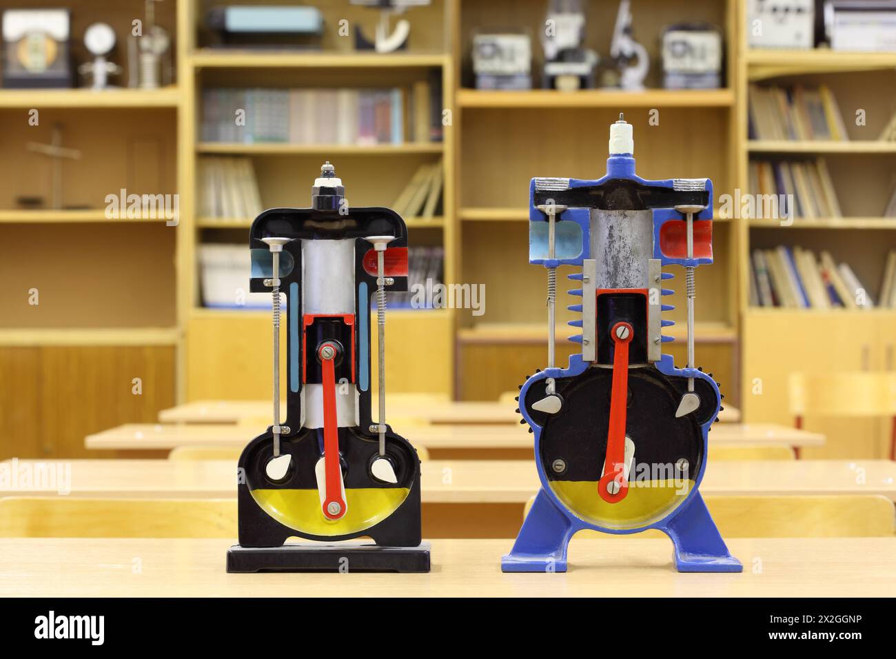 Due modelli di motore a combustione interna sulla scrivania in classe di fisica vuota Foto Stock