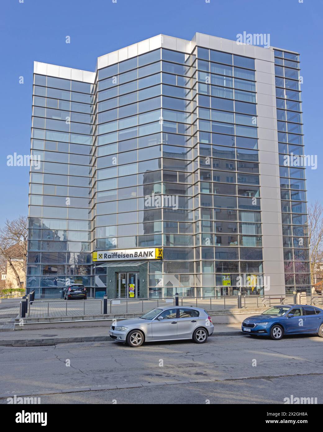 Craiova, Romania - 16 marzo 2024: Edificio moderno per uffici in vetro Raiffeisen Bank Skyscraper presso Sfantu Dumitru Street. Foto Stock