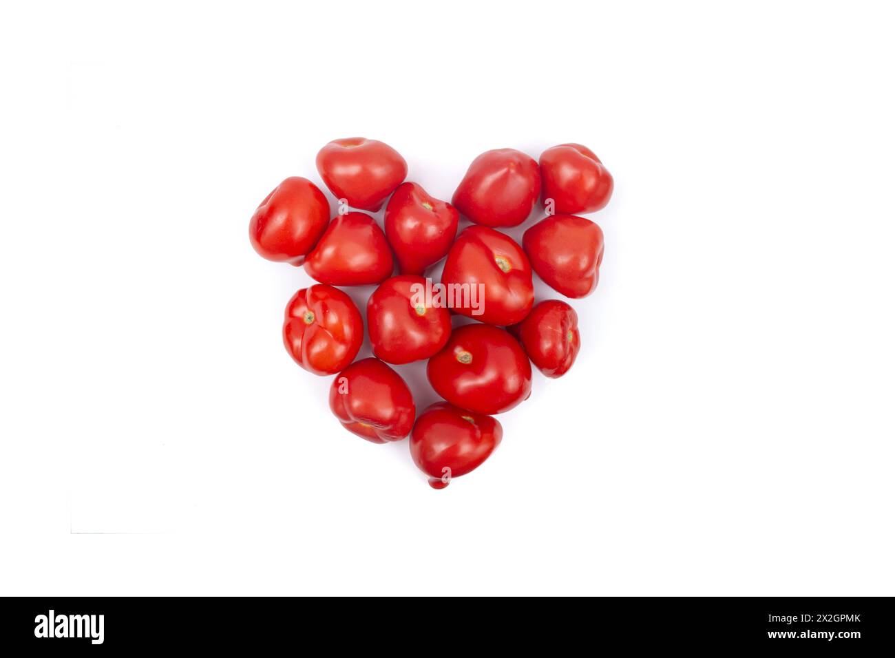 Pomodori disposti a forma di cuore, isolati sul bianco Foto Stock