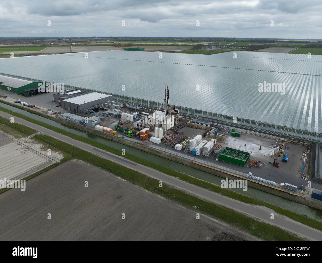 Estrazione del calore geotermico da sotto la superficie di erath. Industria energetica, costruzione di un nuovo sito. Vista aerea con drone. Foto Stock