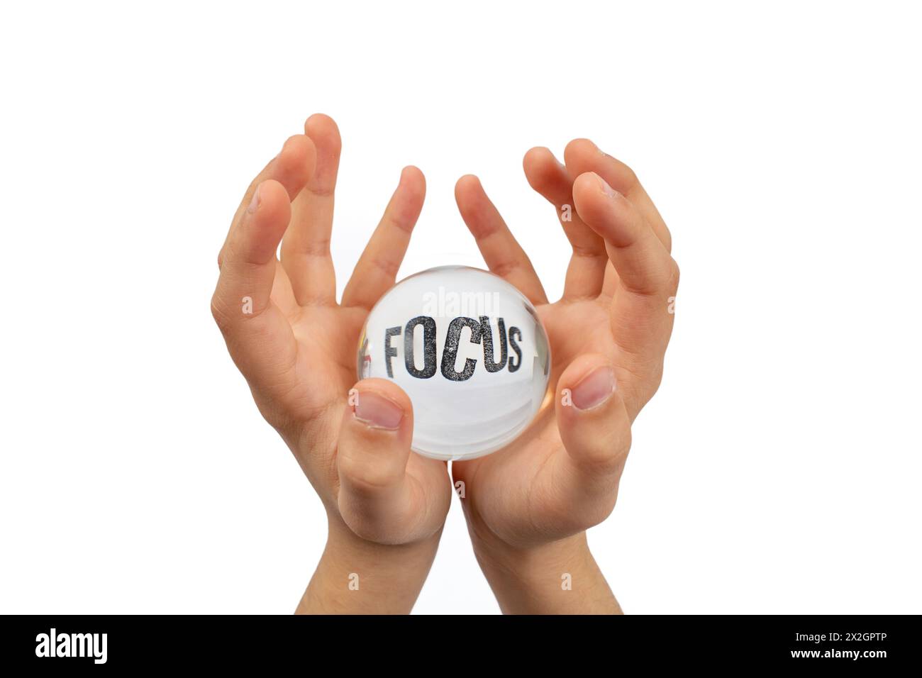 Mani del bambino che reggono una sfera di vetro isolata su sfondo bianco, con la parola messa a fuoco distorta Foto Stock